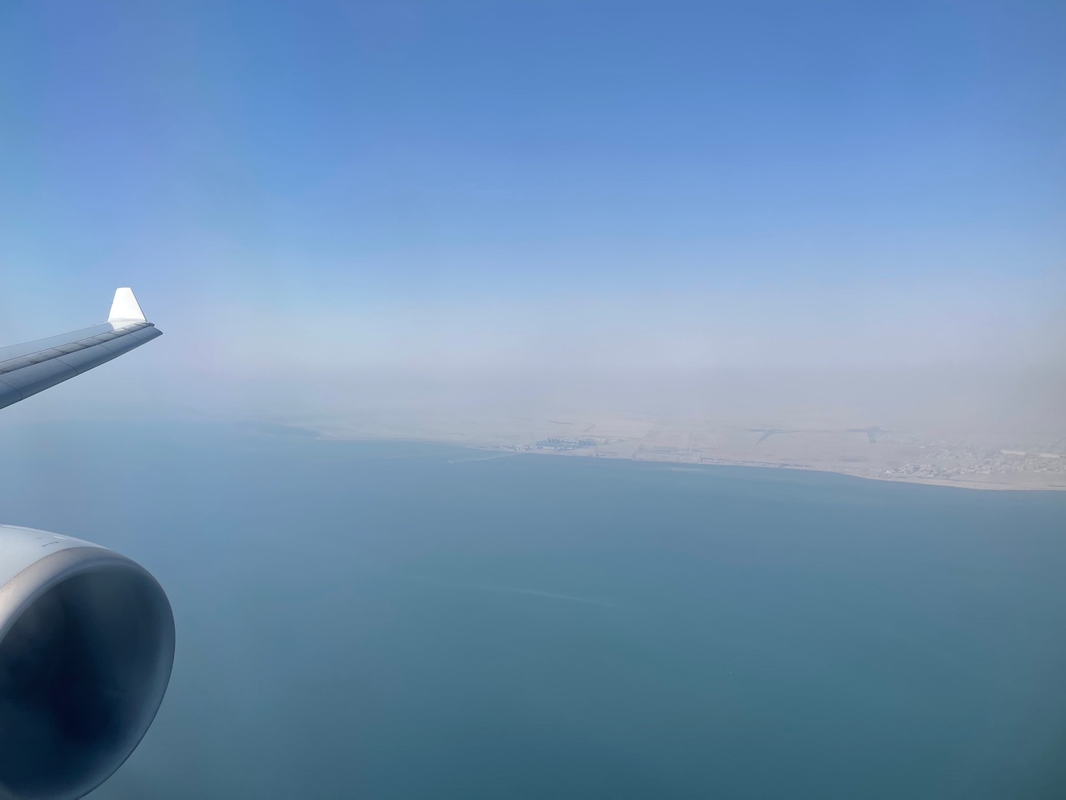 an airplane wing and a body of water