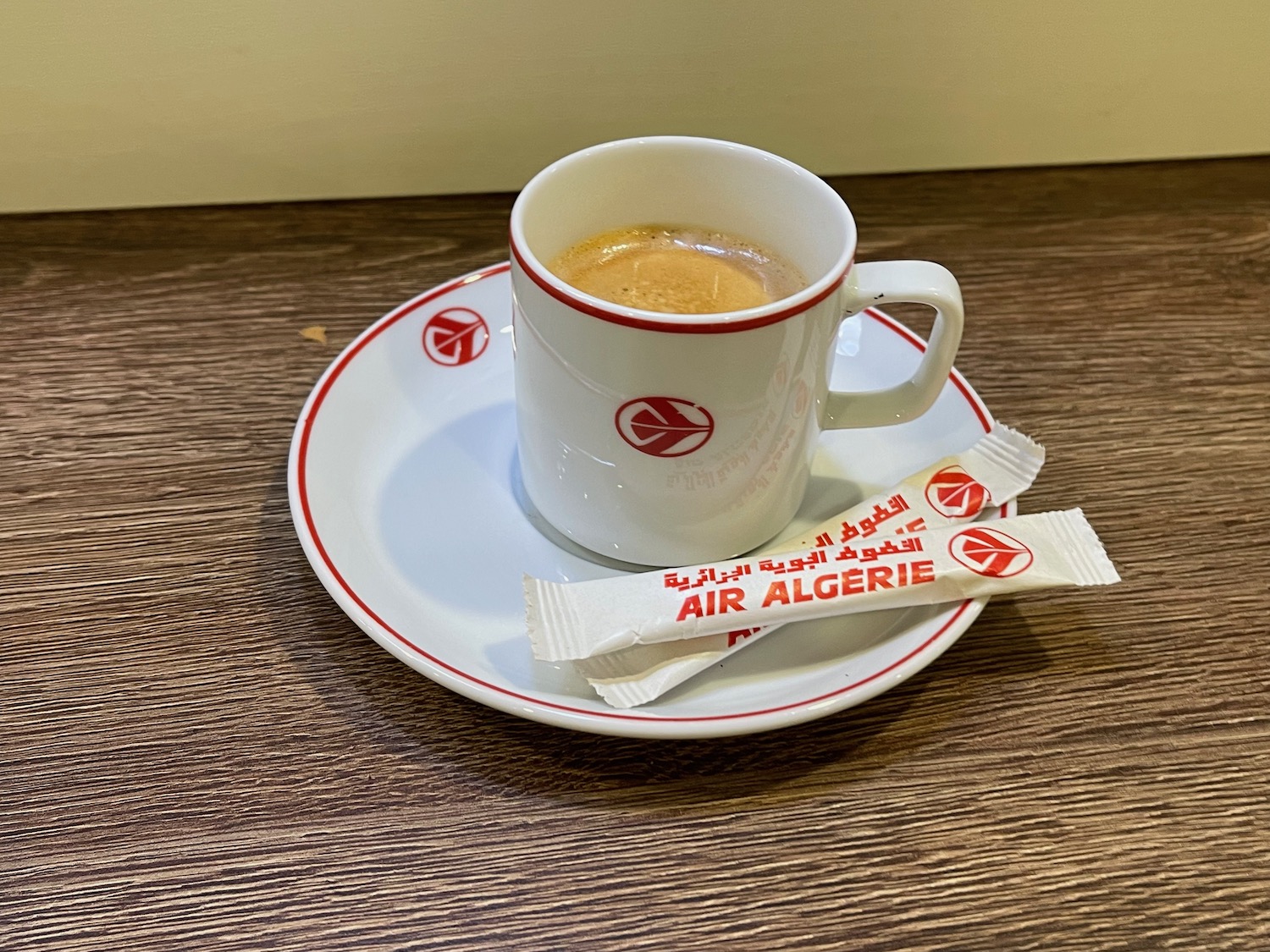 a cup of coffee and sugar packets on a plate