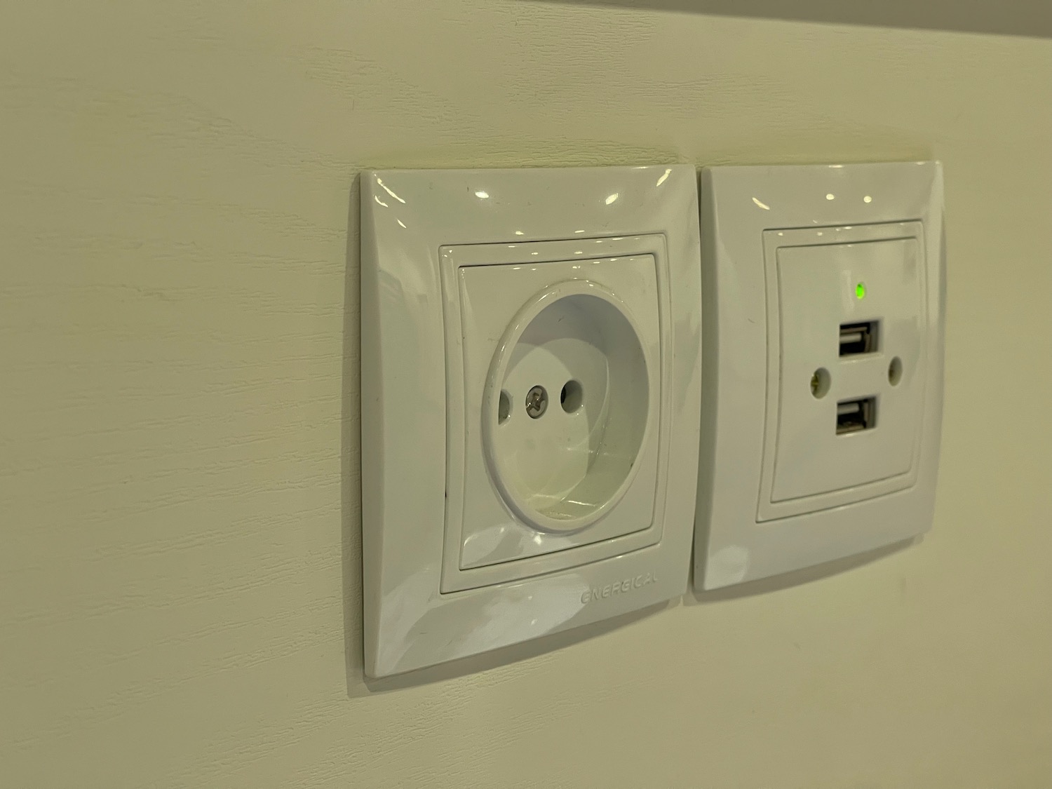 a white outlet with a green light on it
