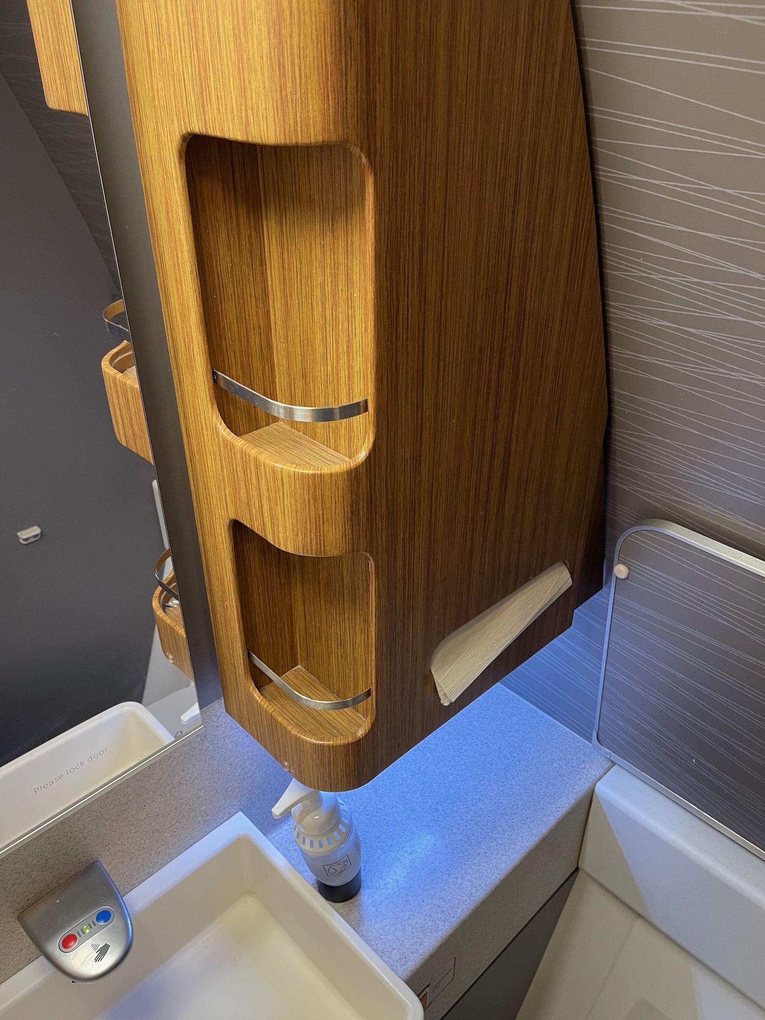 a wooden shelf with a sink and soap dispenser