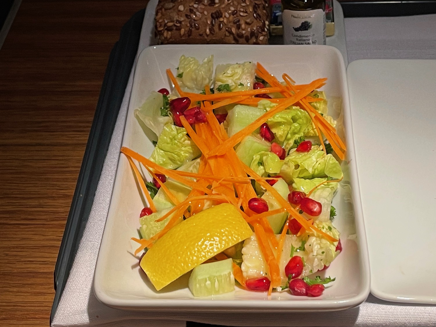 a plate of salad with carrots and a lemon