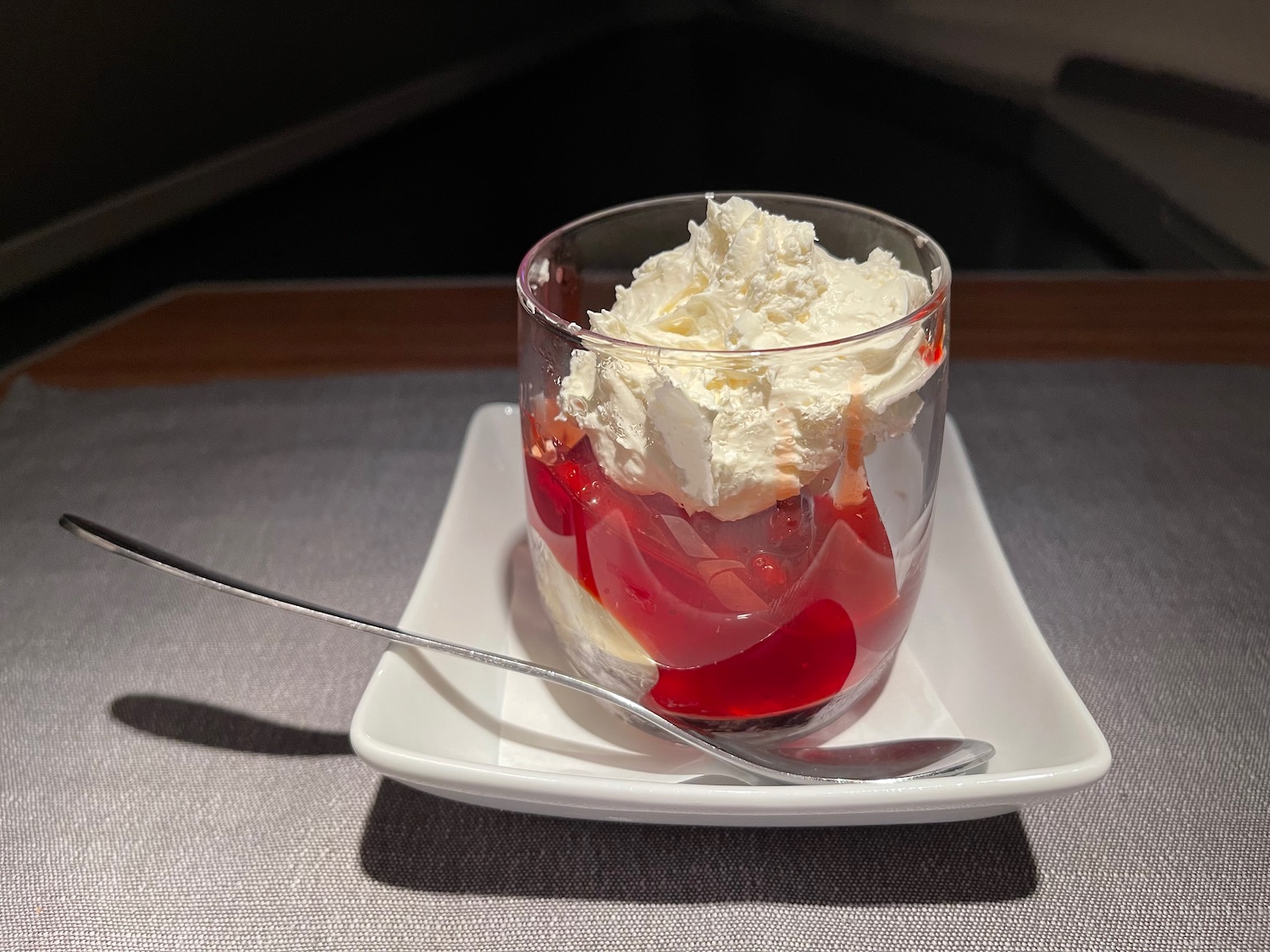 a dessert in a glass with whipped cream and a spoon