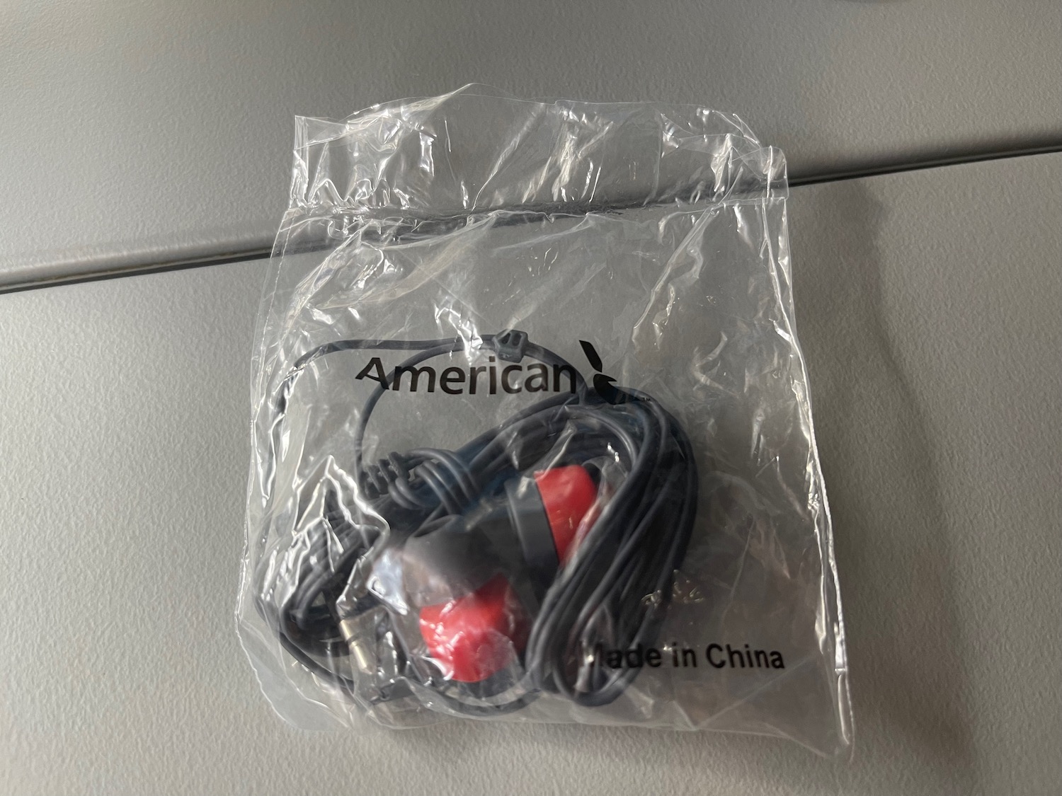 a black and red earbuds in a plastic bag