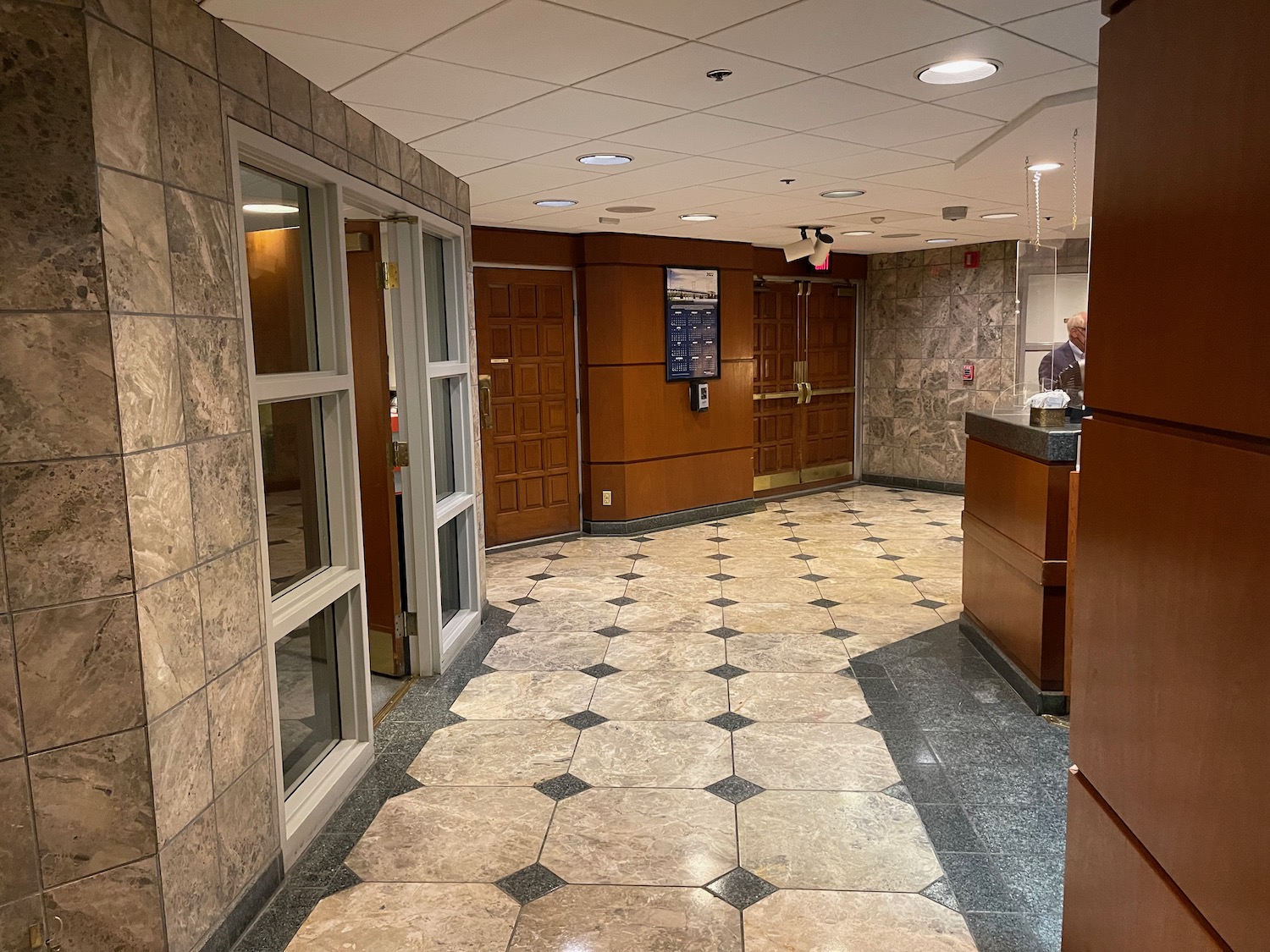 a hallway with a reception desk and a door