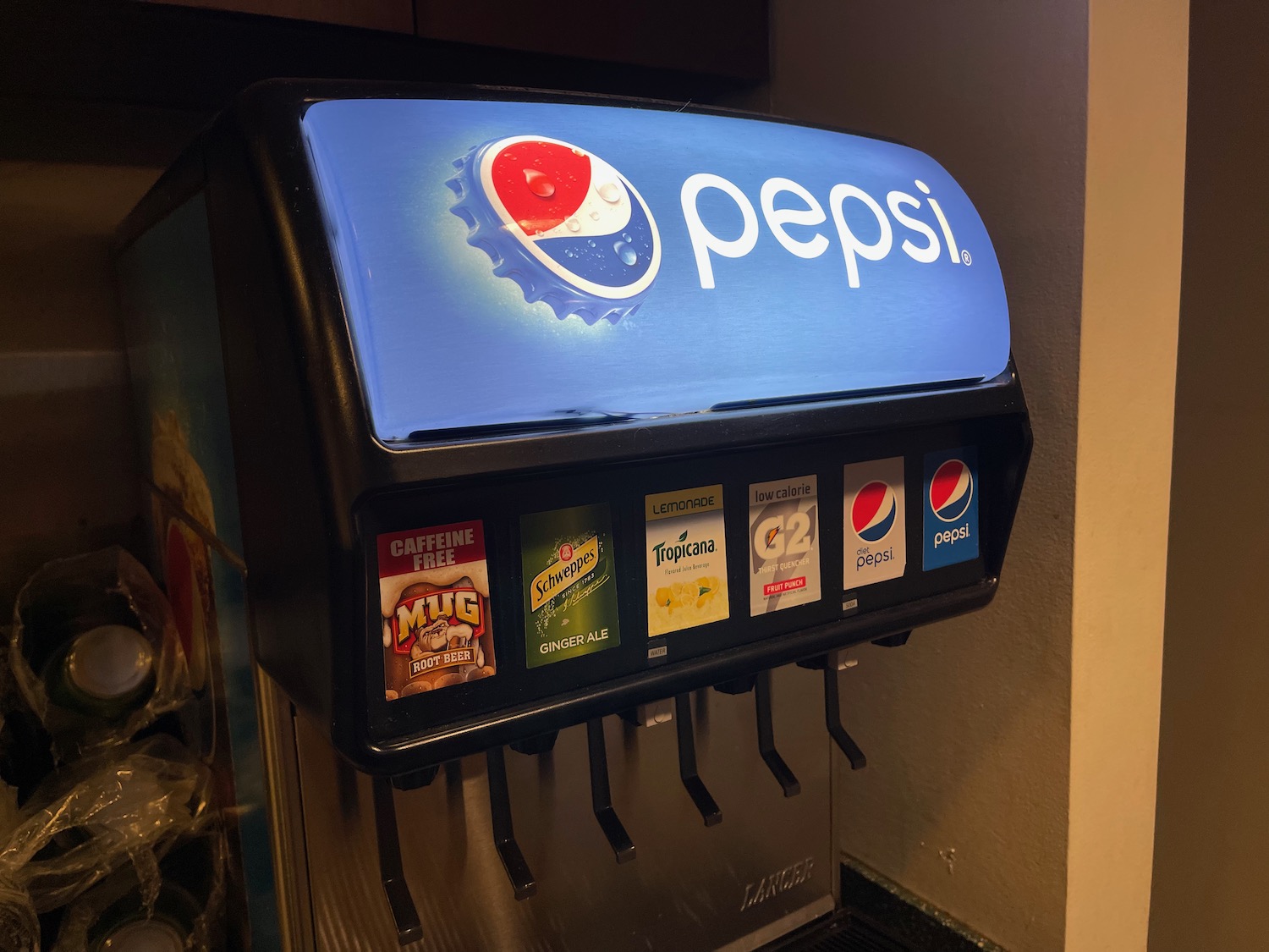 a soda dispenser with a blue sign