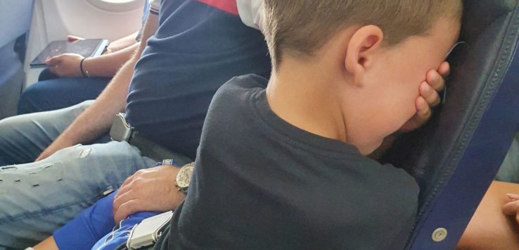 a boy sitting on a plane