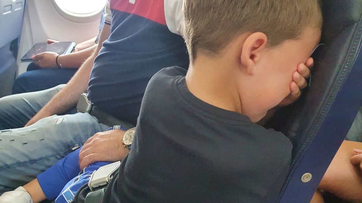 a boy sitting on a plane