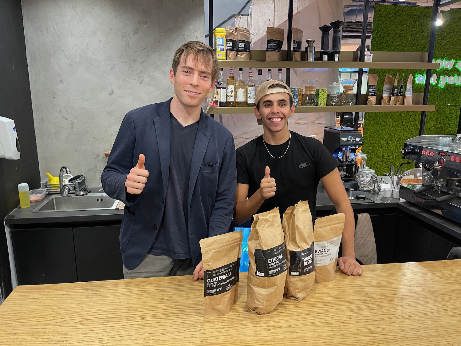 two men standing next to a table with bags