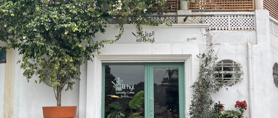 a building with a green door and a bench