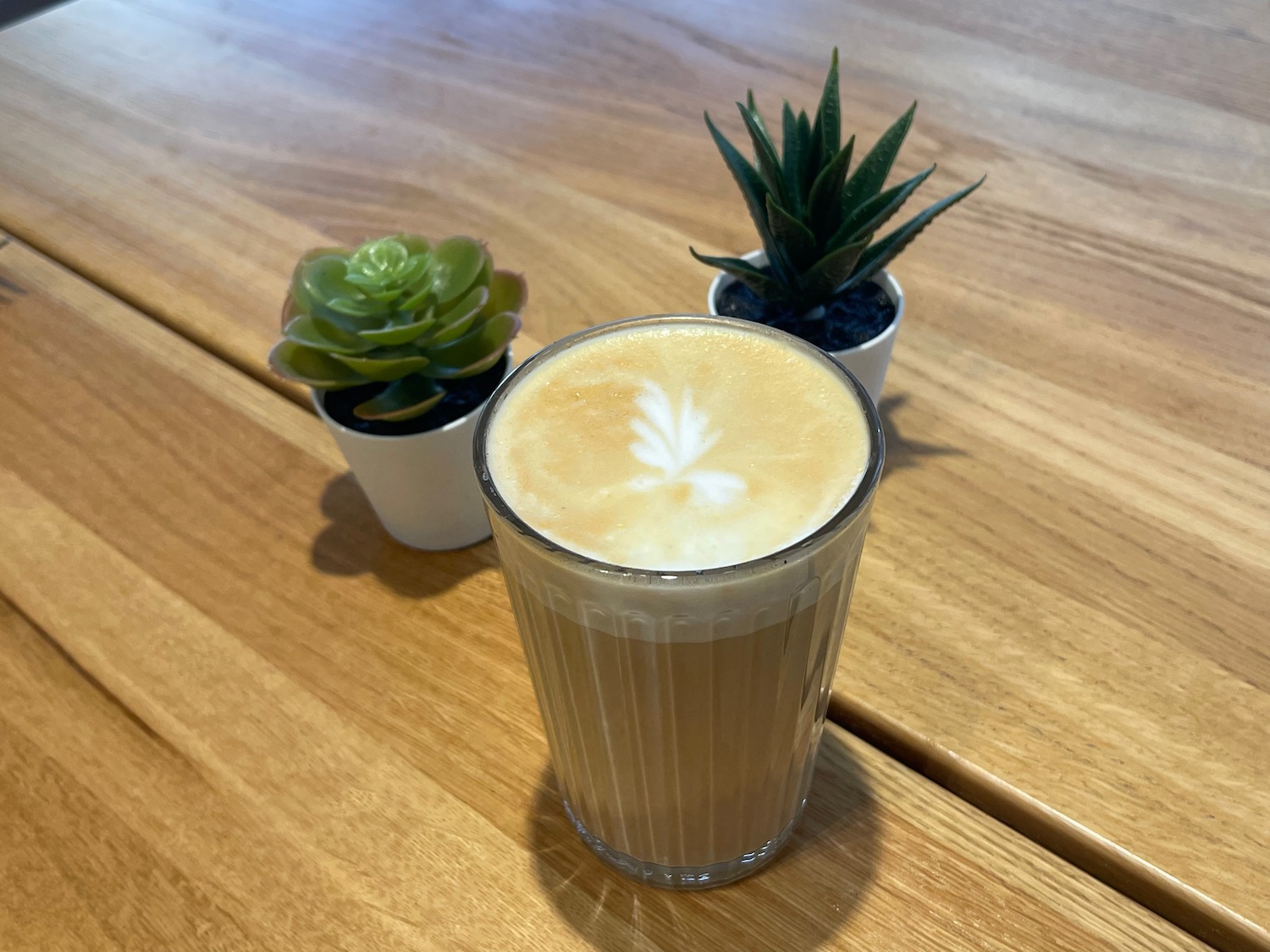 a glass of coffee with a leaf design on top of it