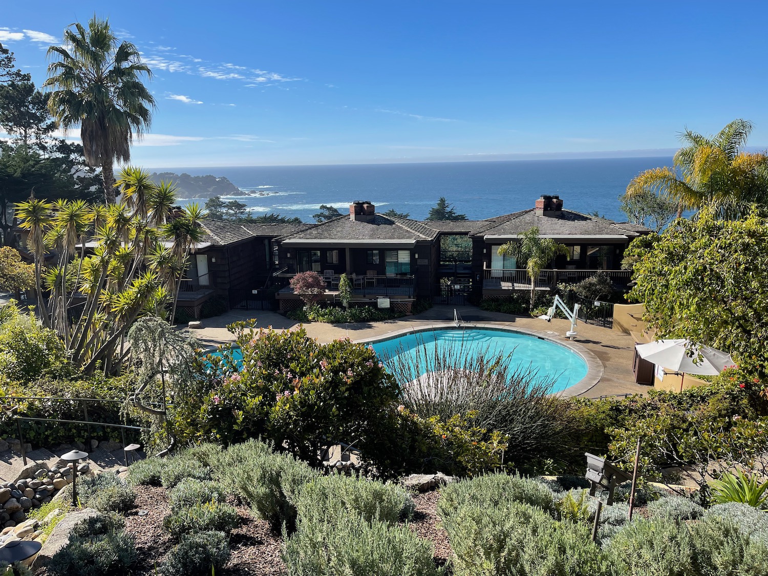 a swimming pool with a house and a beach in the background