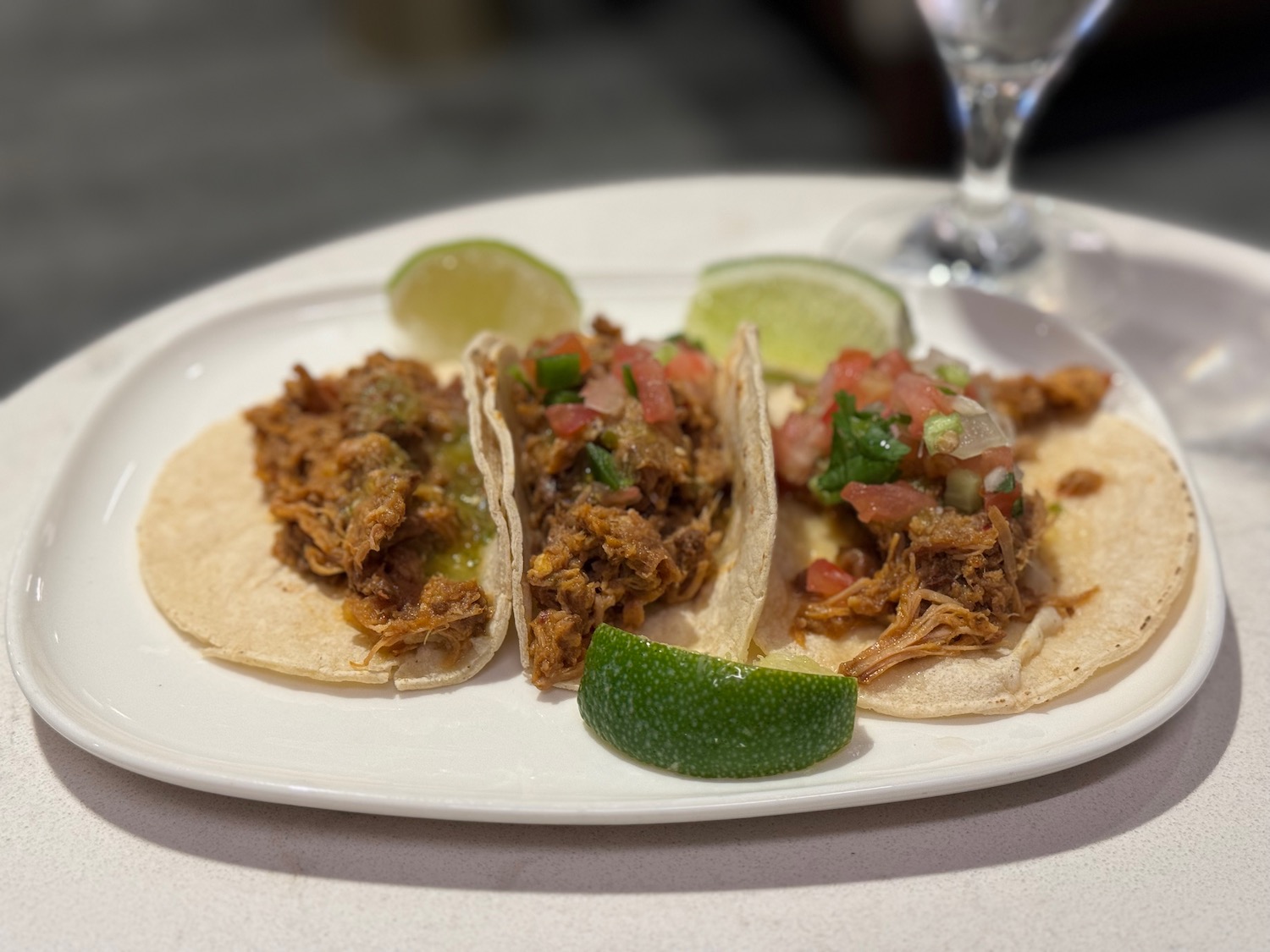 a plate of tacos with meat and limes