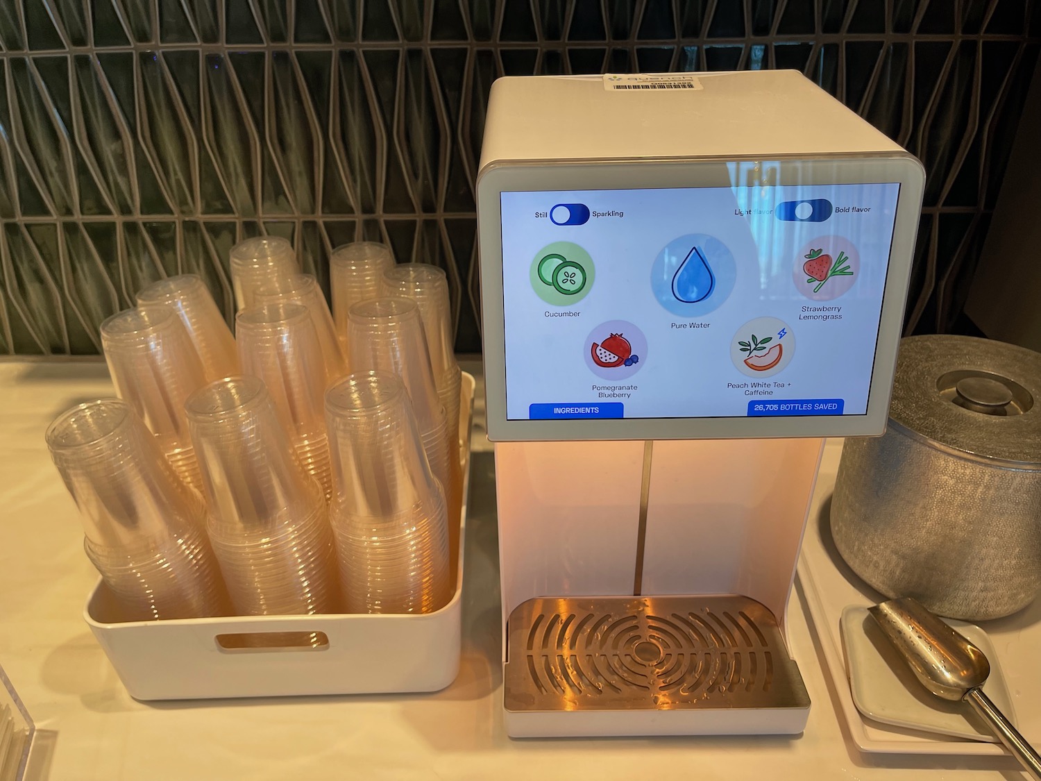 a machine with a screen and a tray of plastic cups