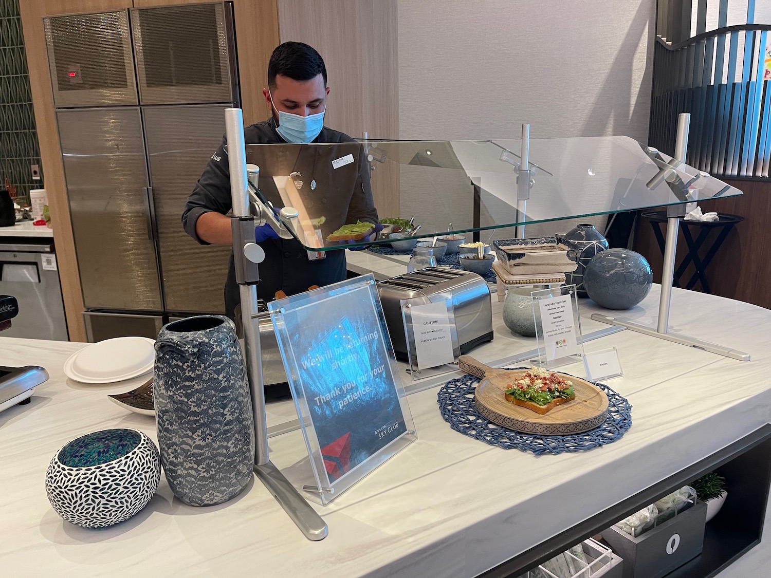 a man wearing a face mask behind a counter