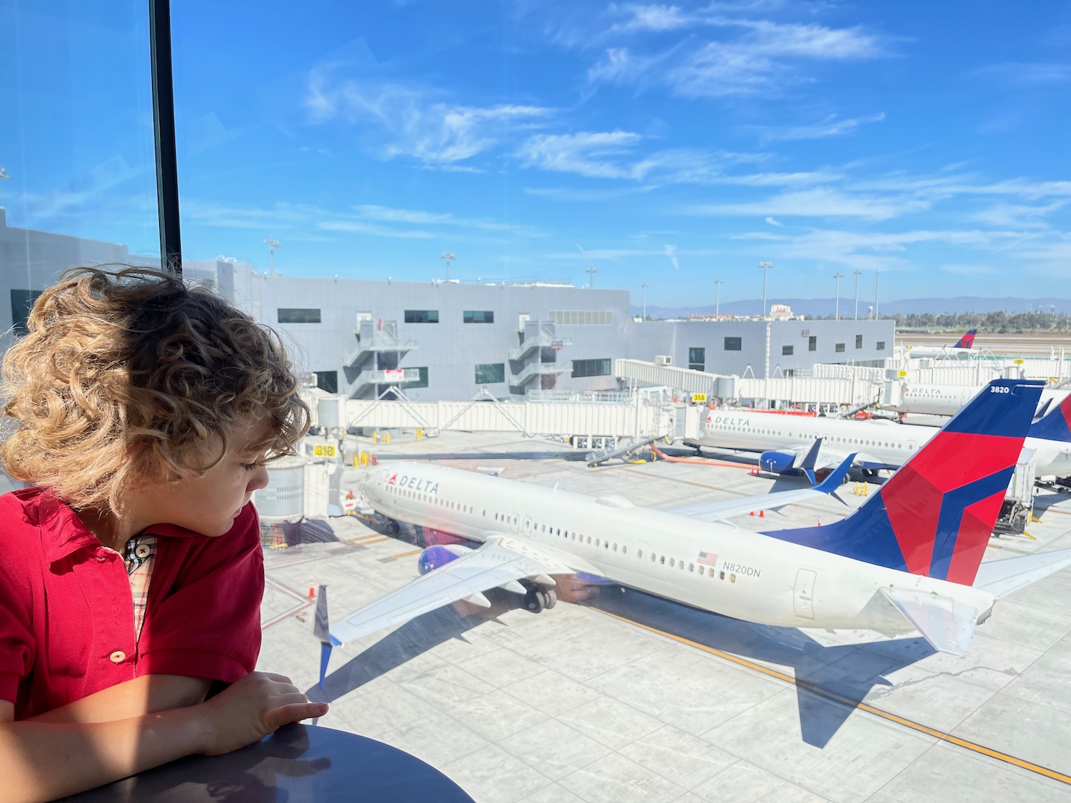 a child looking out a window at an airplane