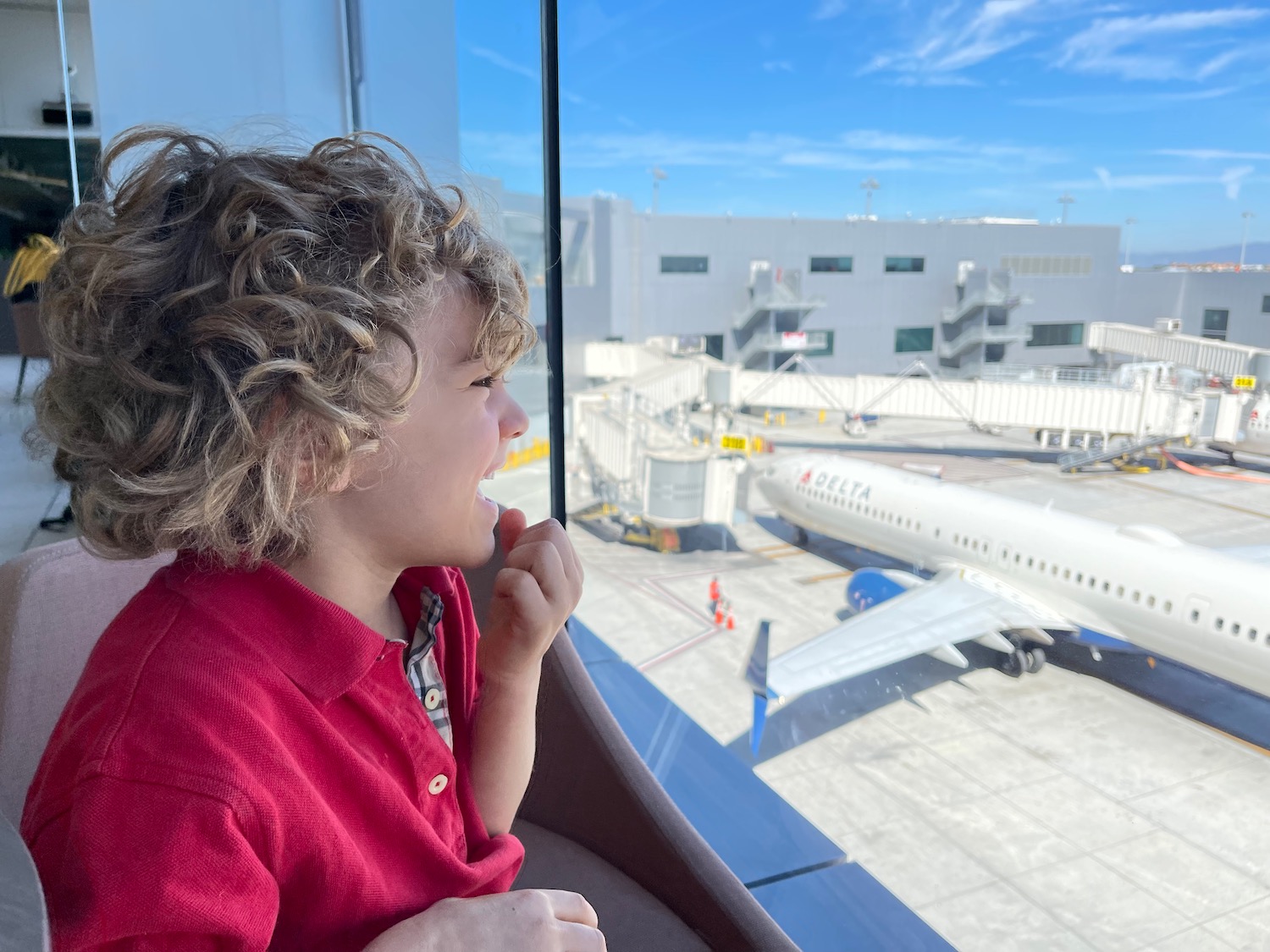 a child looking out a window at an airplane