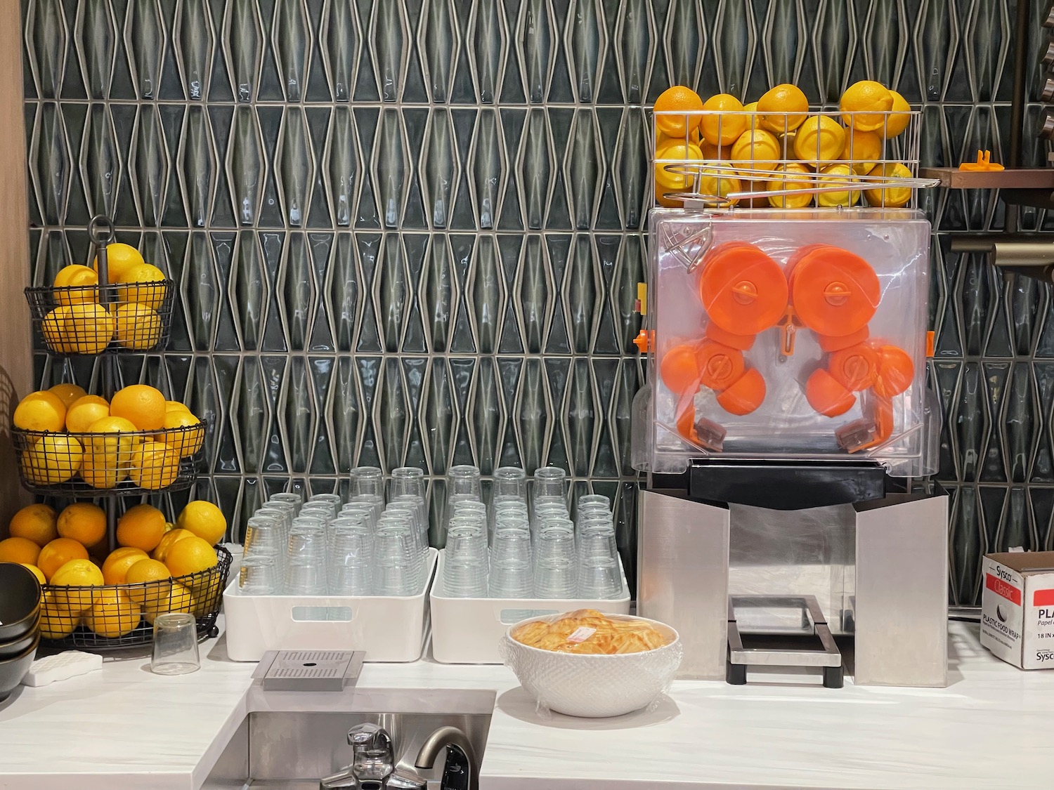 a juice machine with oranges and bottles
