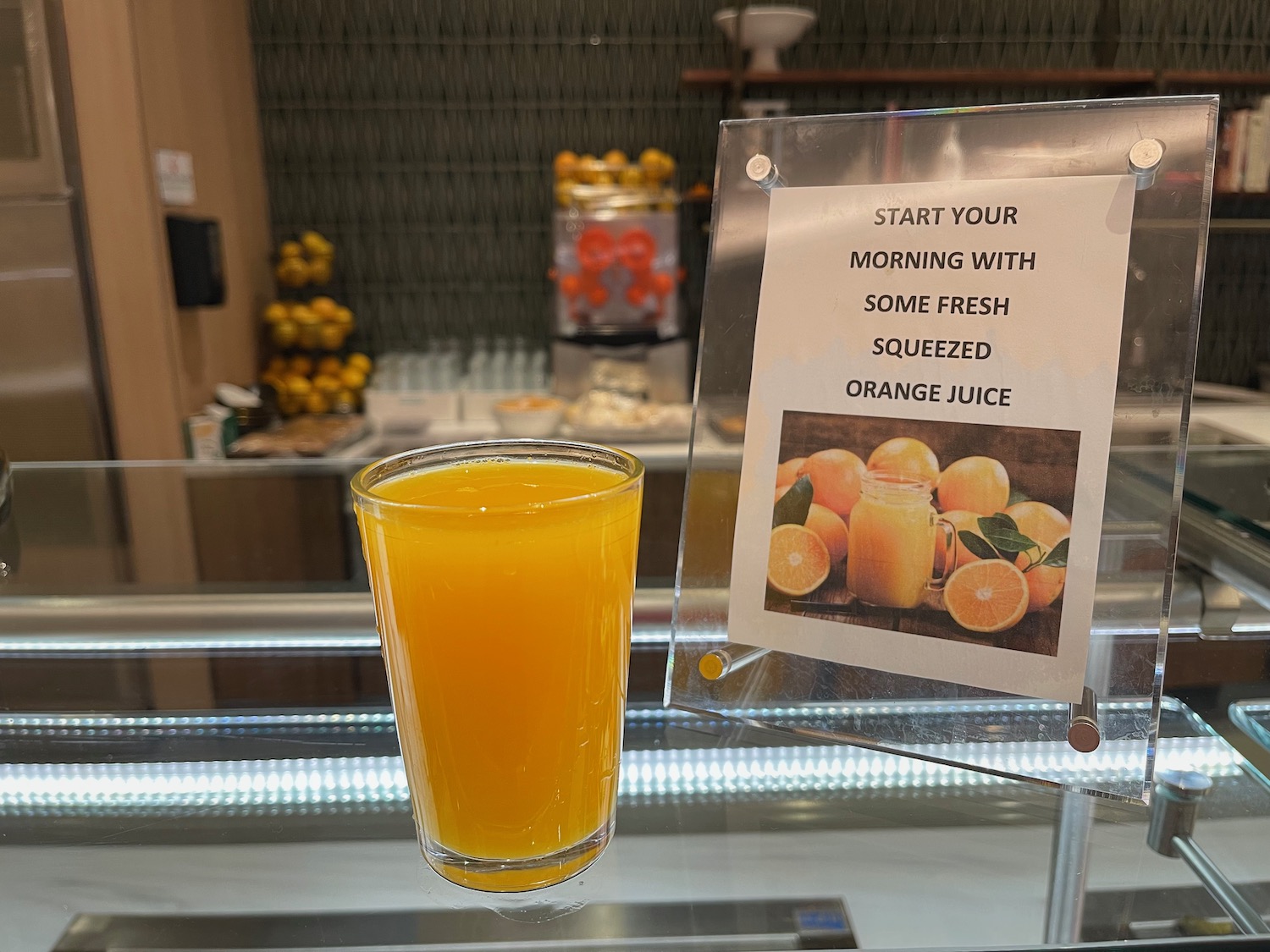 a glass of orange juice next to a sign