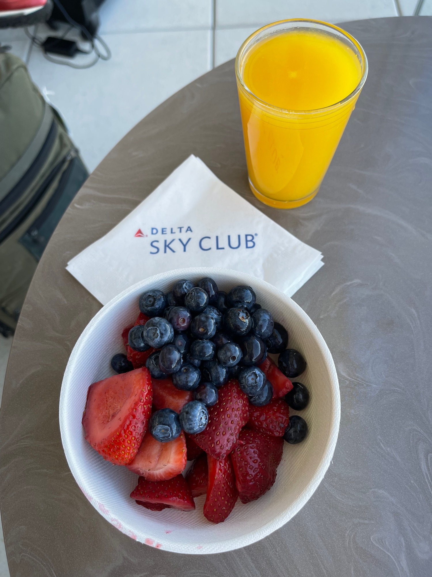 a bowl of fruit and a glass of orange juice