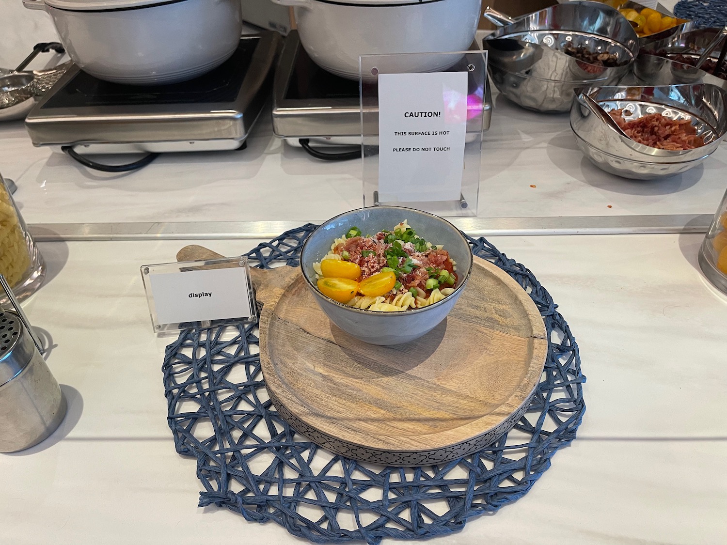 a bowl of pasta and vegetables on a wood plate