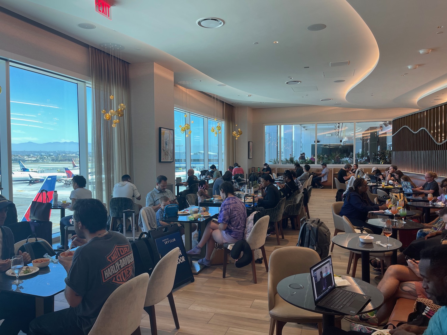 a group of people sitting at tables in a room with windows