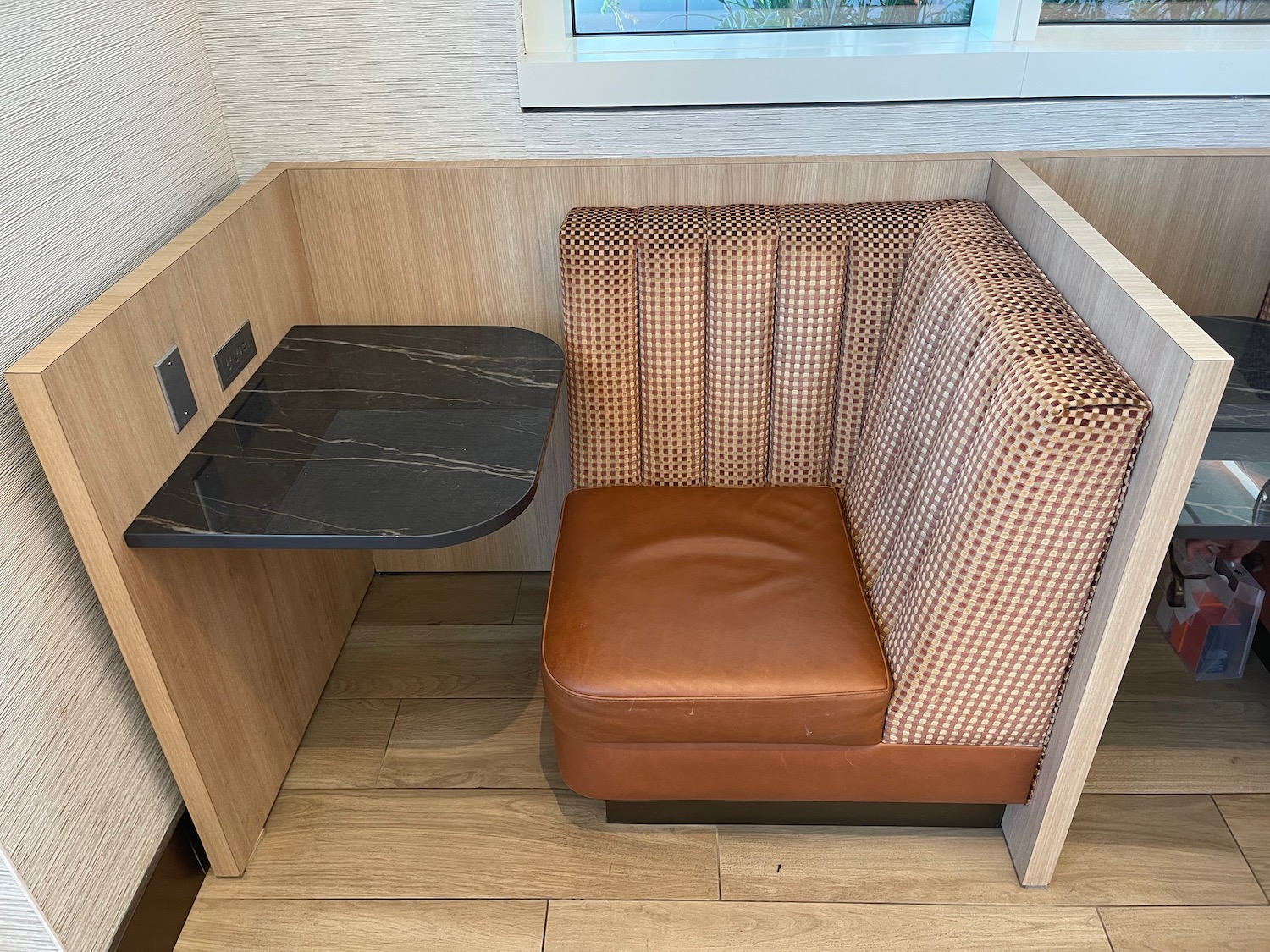 a booth with a table and a brown chair