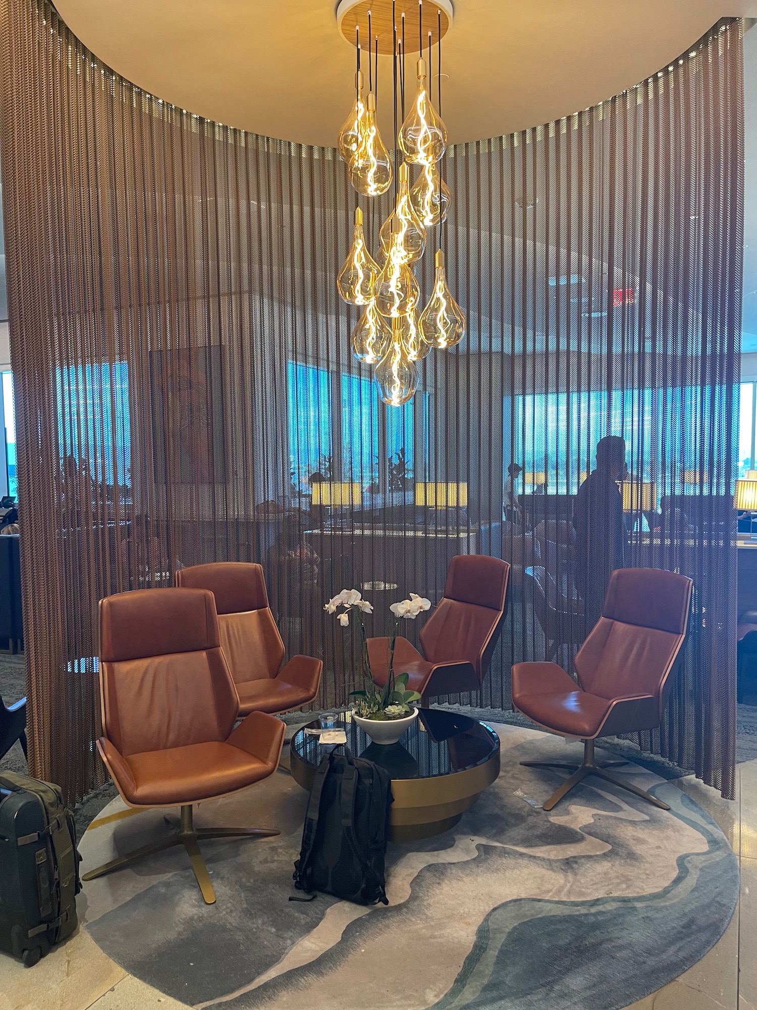 a room with brown chairs and a chandelier