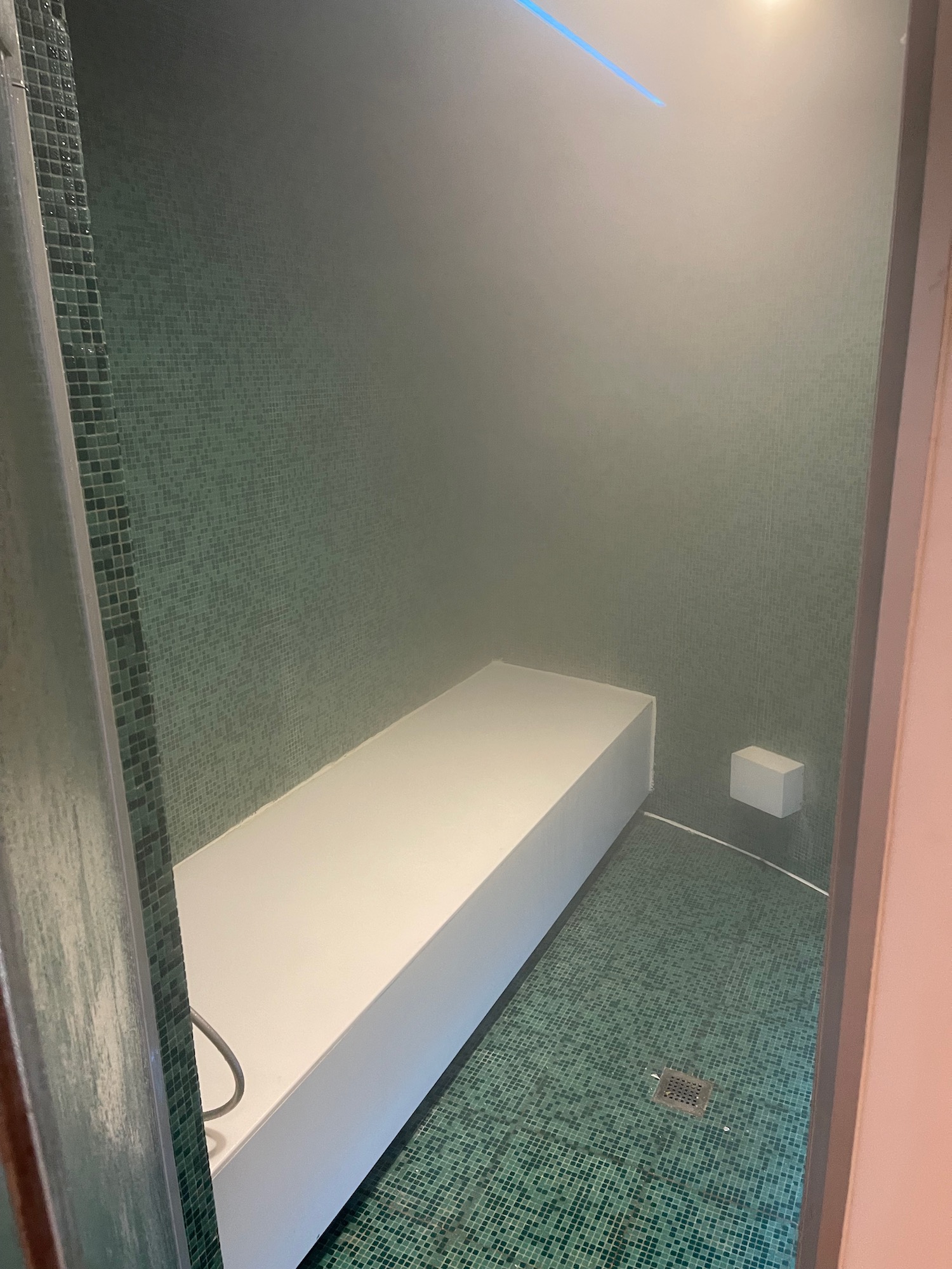 a shower with a white bench