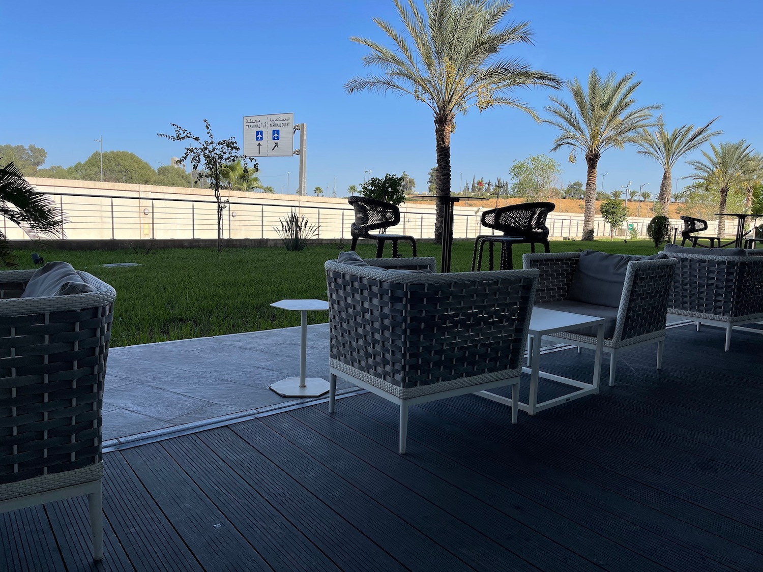 a patio with chairs and tables and a lawn