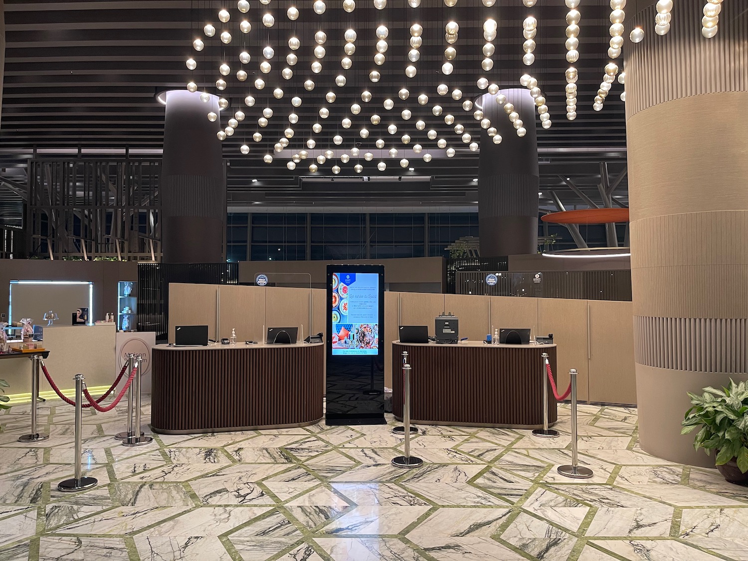 a reception area with a large chandelier and a large screen