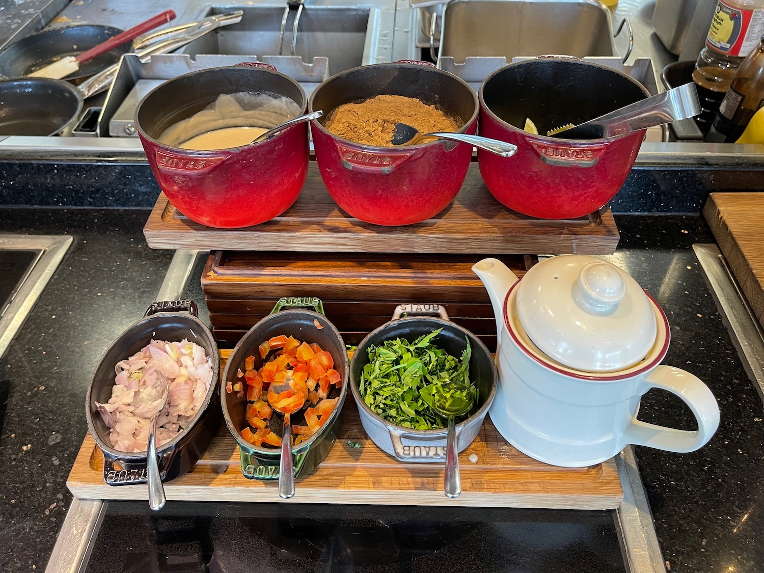 a group of pots with different ingredients on a wooden board