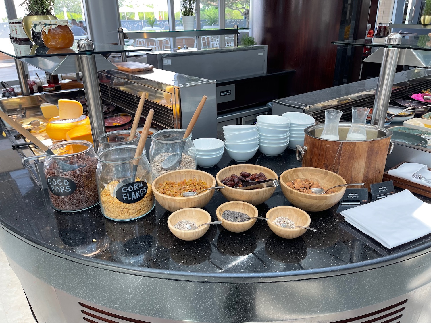 a counter with bowls of food and bowls of cereals