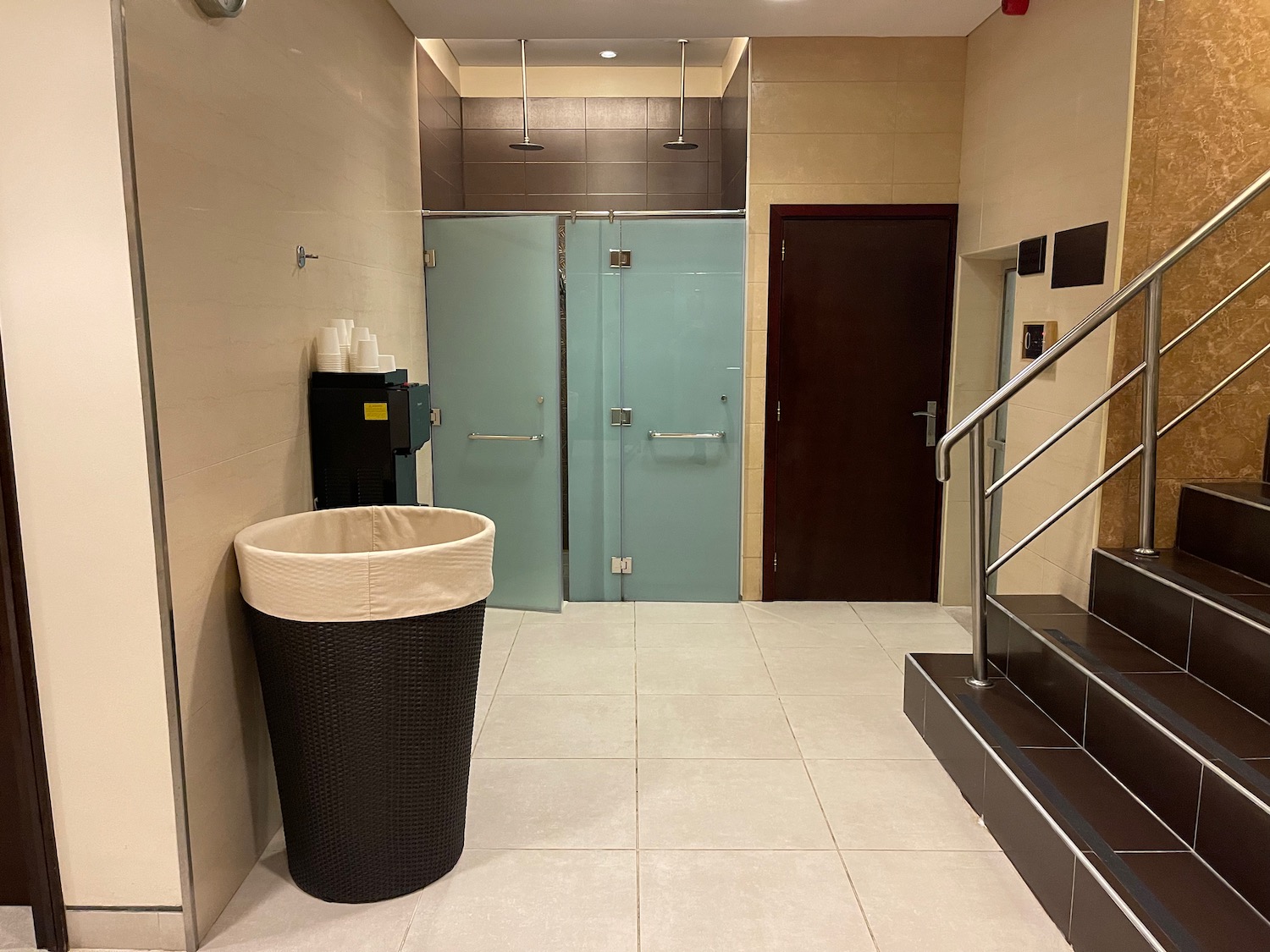 a bathroom with a trash can and blue doors