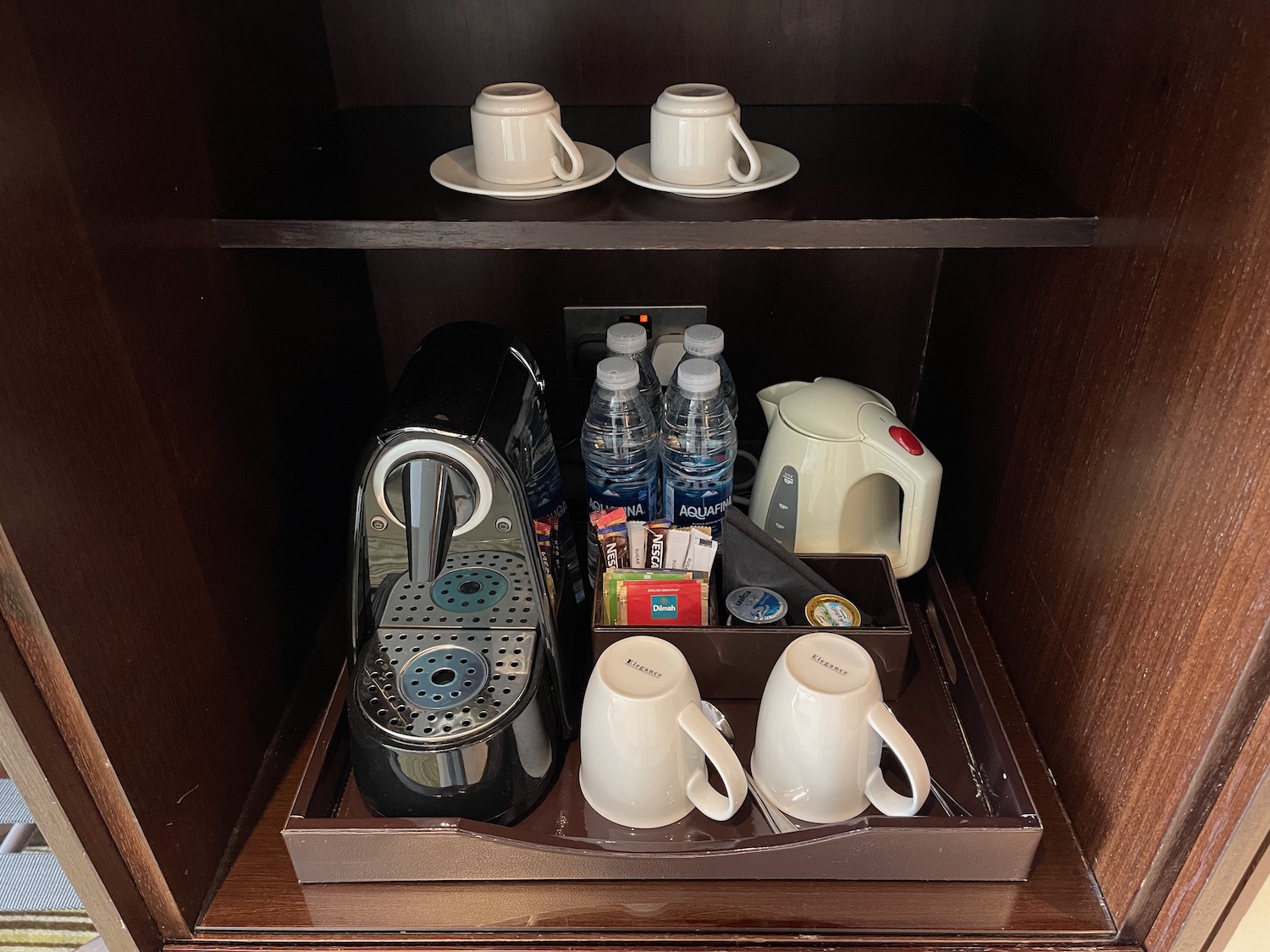 a coffee maker and cups in a drawer