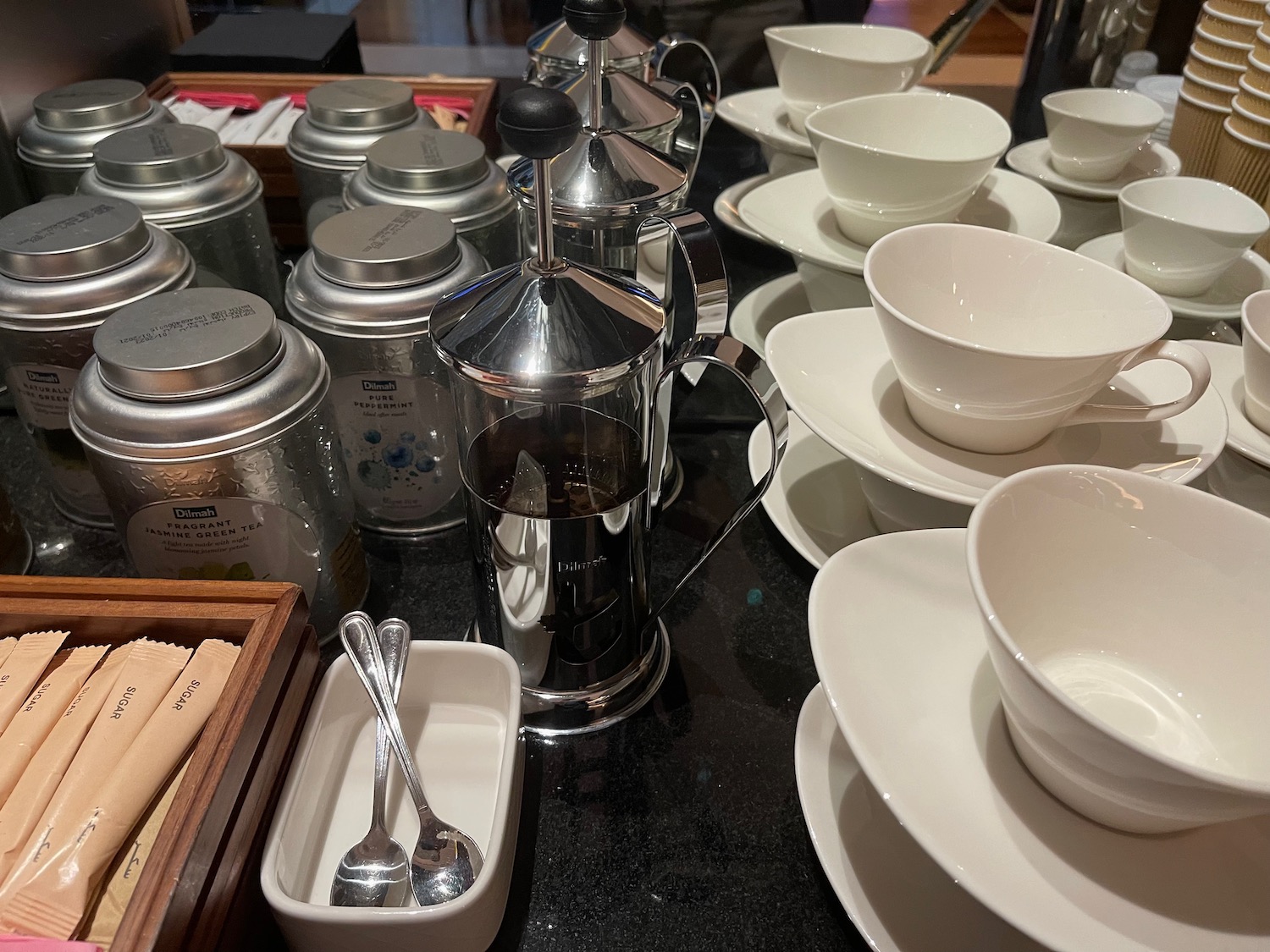 a group of white cups and saucers on a table