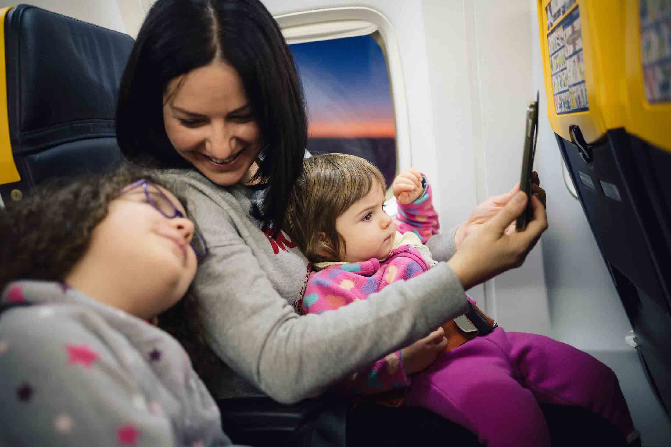 a woman and two children on a plane