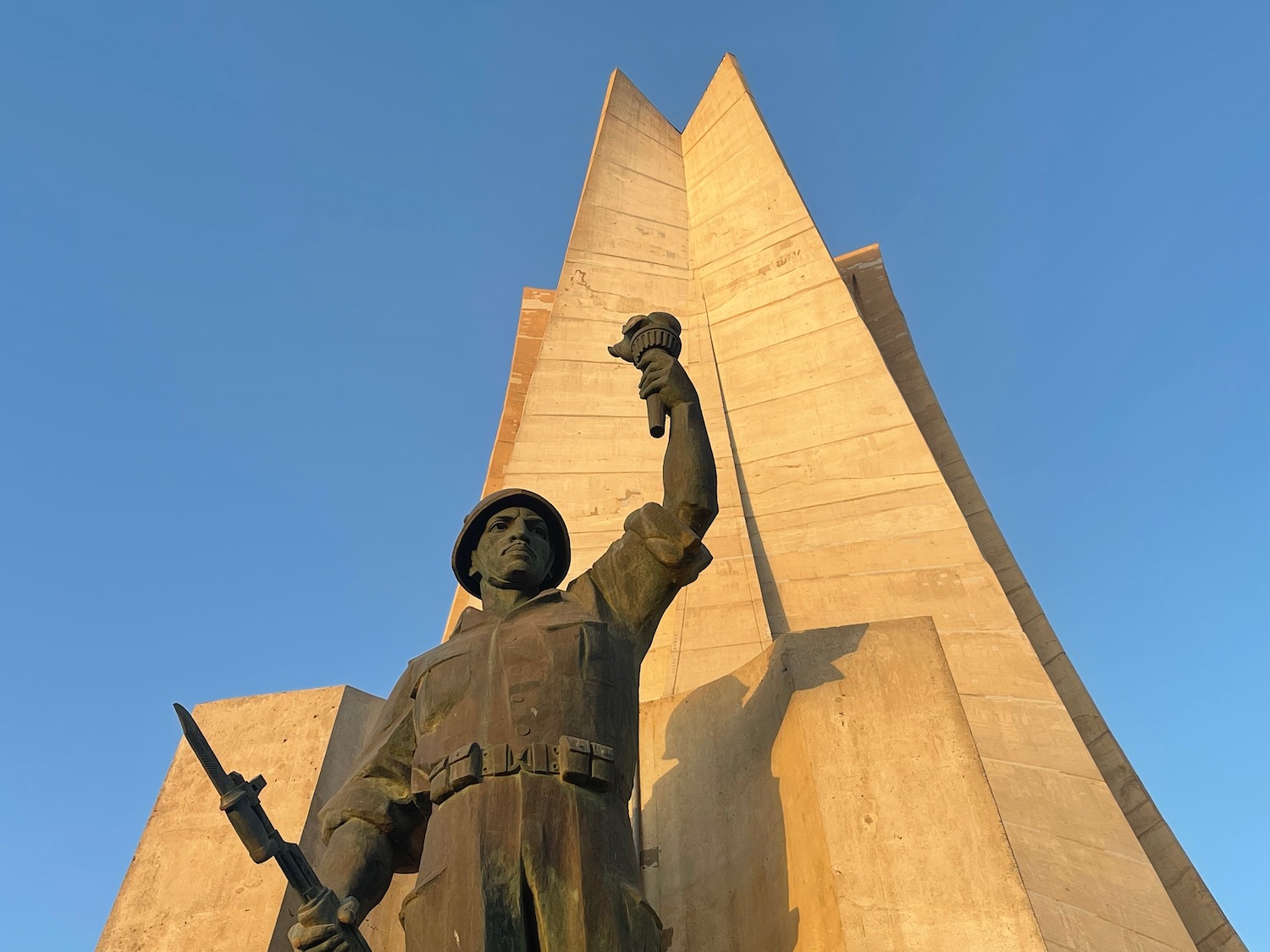 a statue of a man holding a torch and a large tower