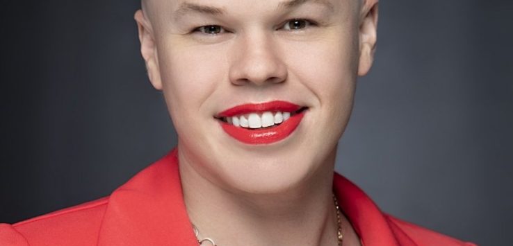 a bald woman wearing a red jacket and red lipstick