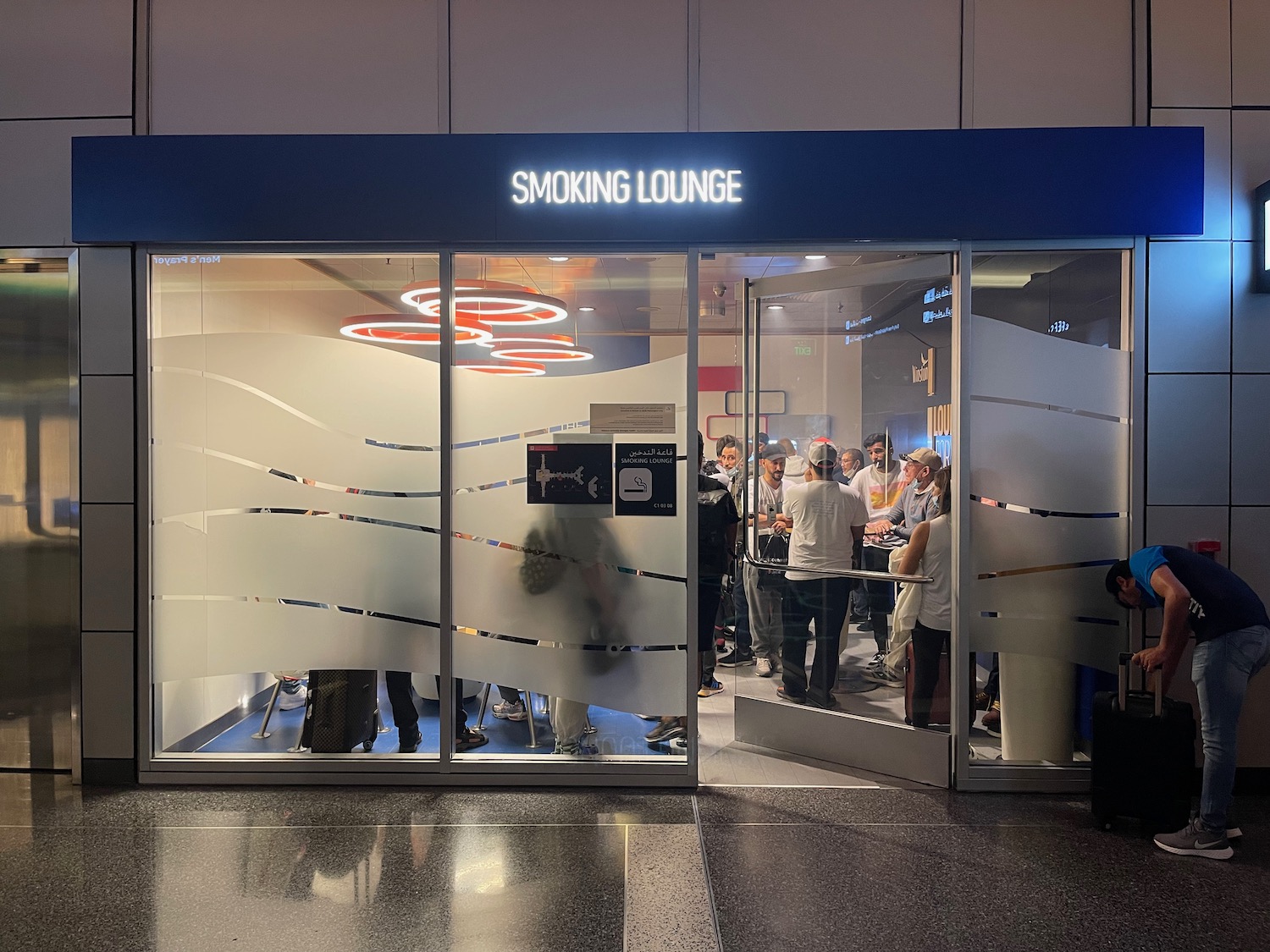 a group of people standing in a line outside a glass door