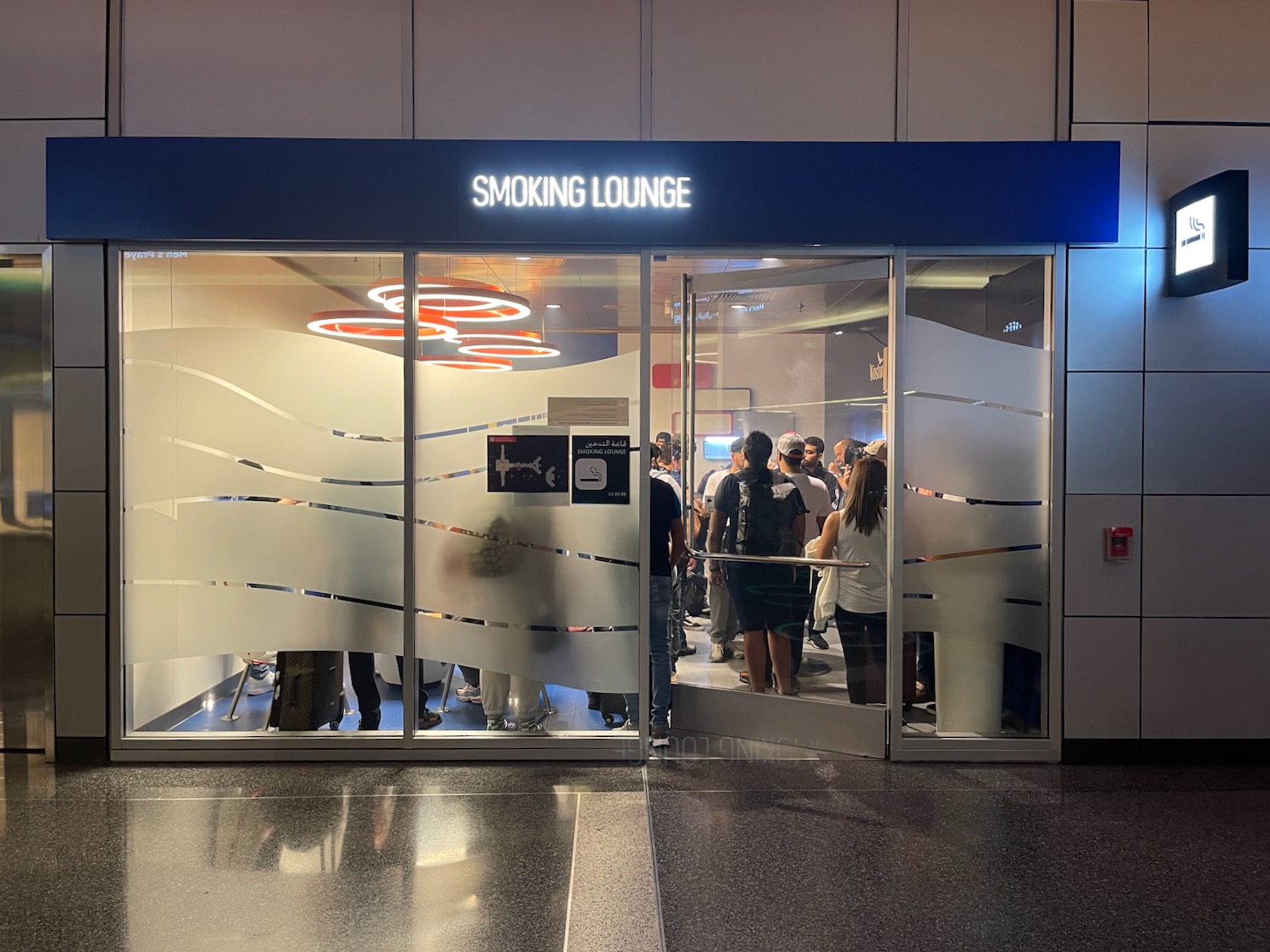 a group of people standing in a line outside a glass door