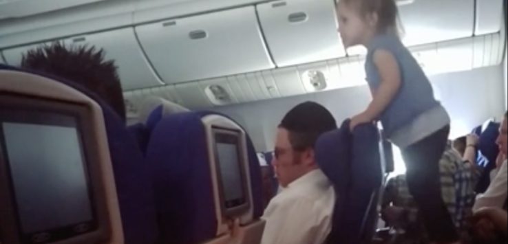 a child climbing on a chair in an airplane