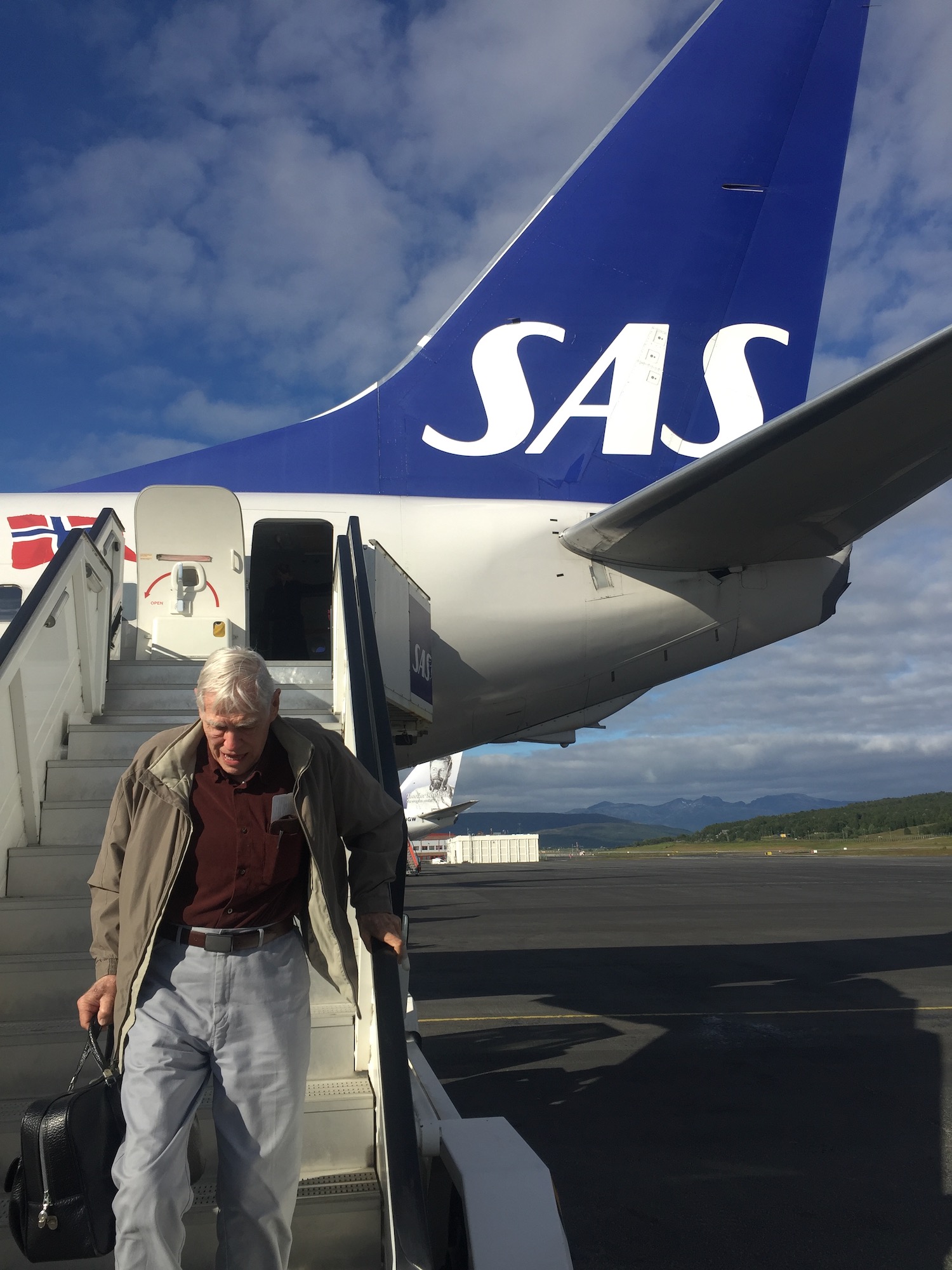 a man walking up the stairs of an airplane