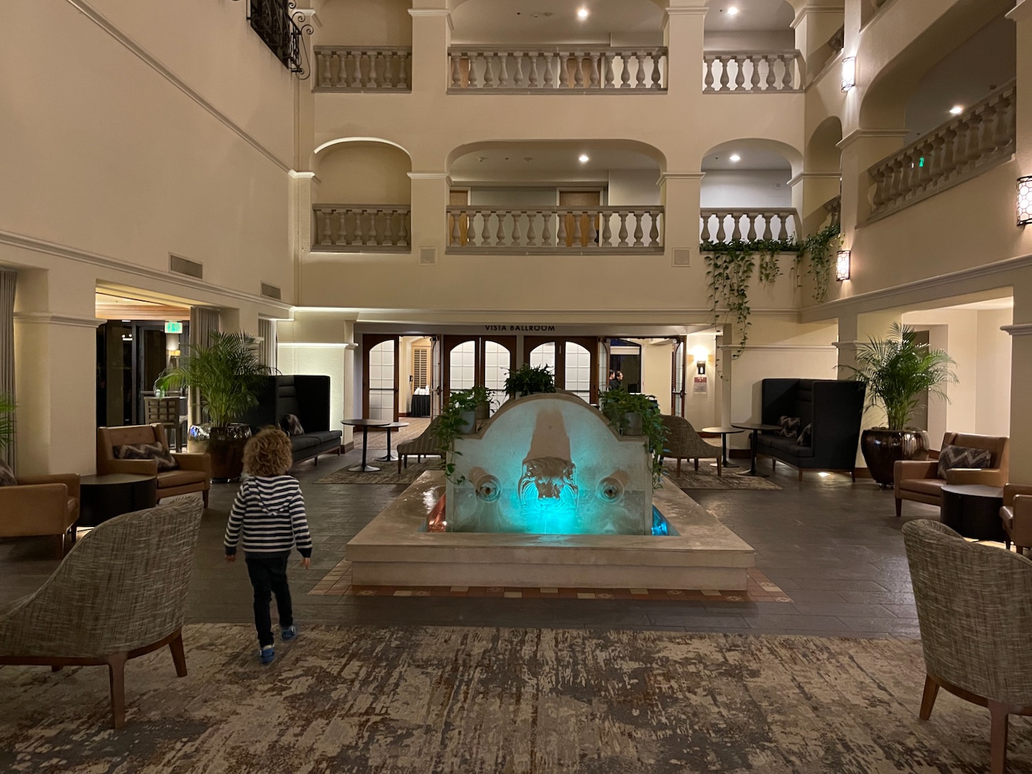 a child standing in a room with a fountain