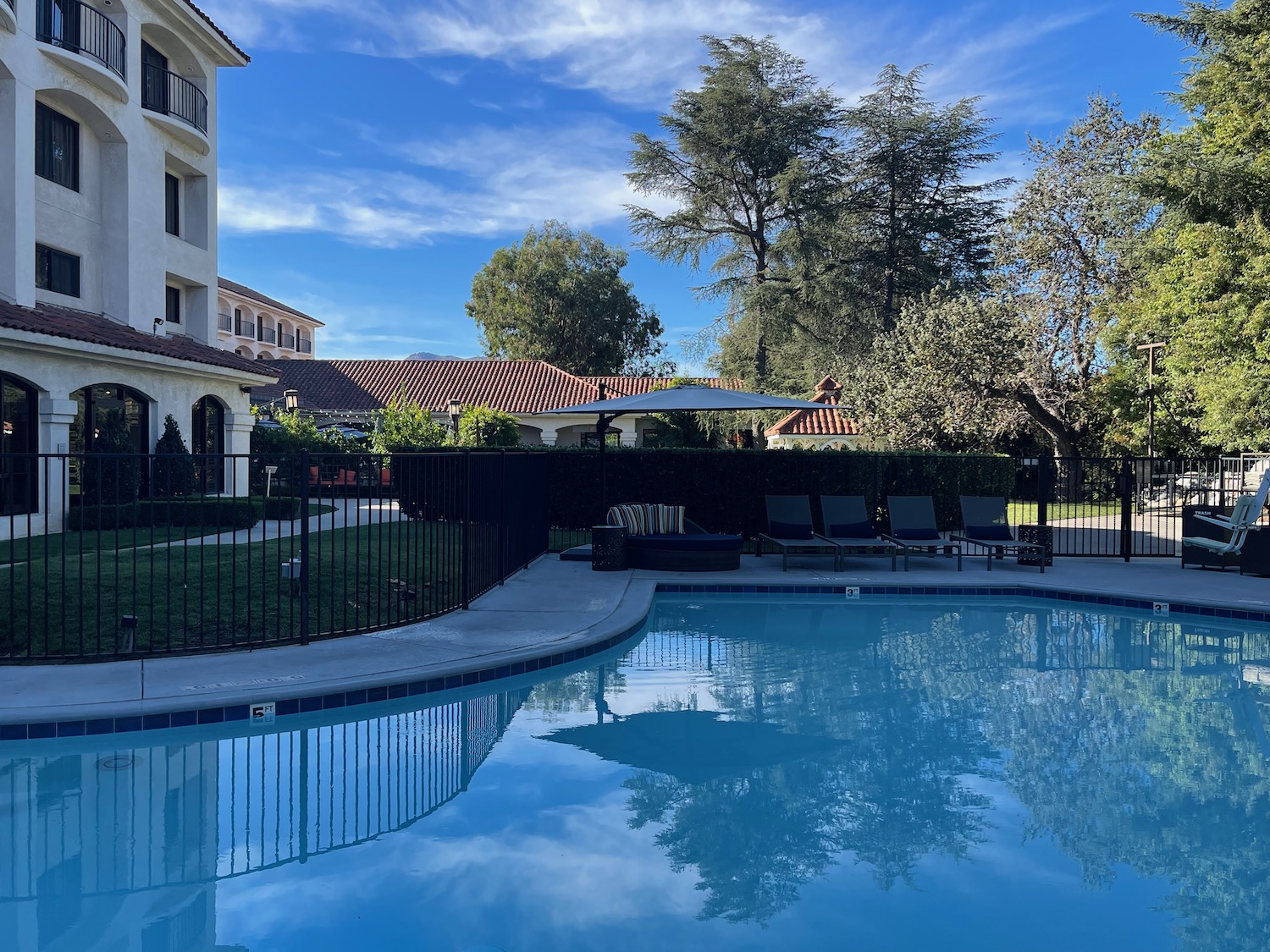 a pool with chairs and a fence