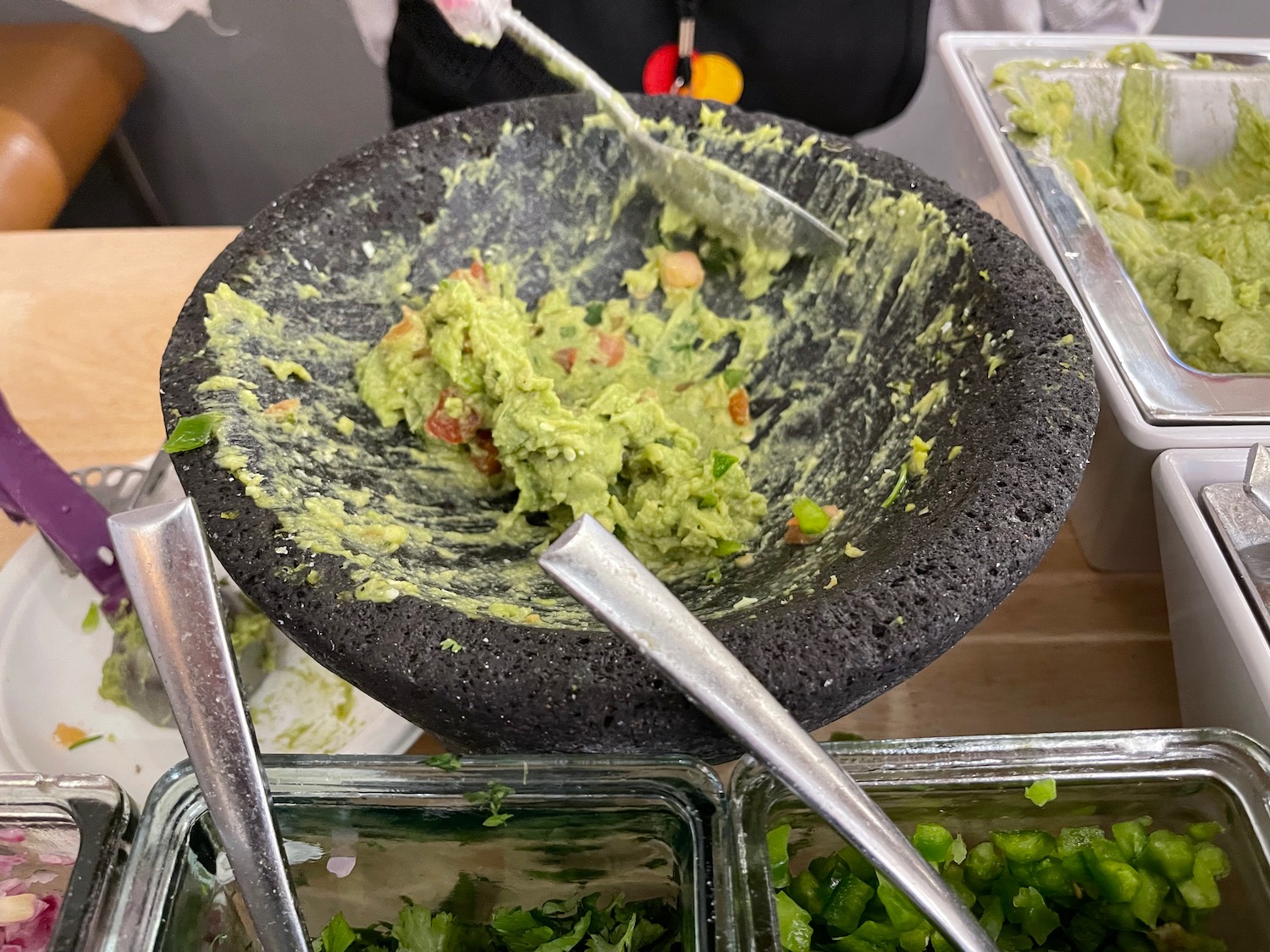 a bowl of guacamole and spoons