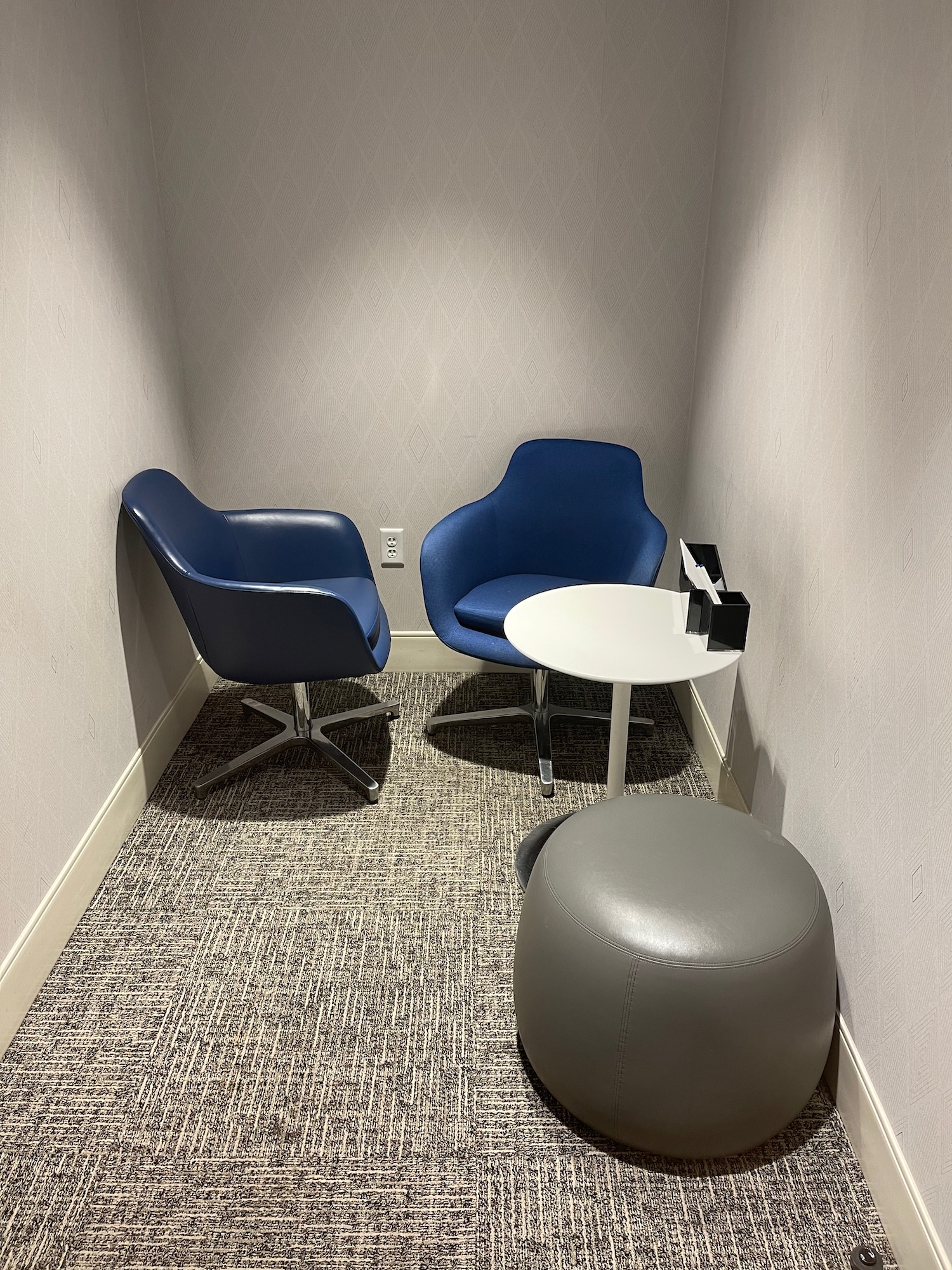 a small room with blue chairs and a round table