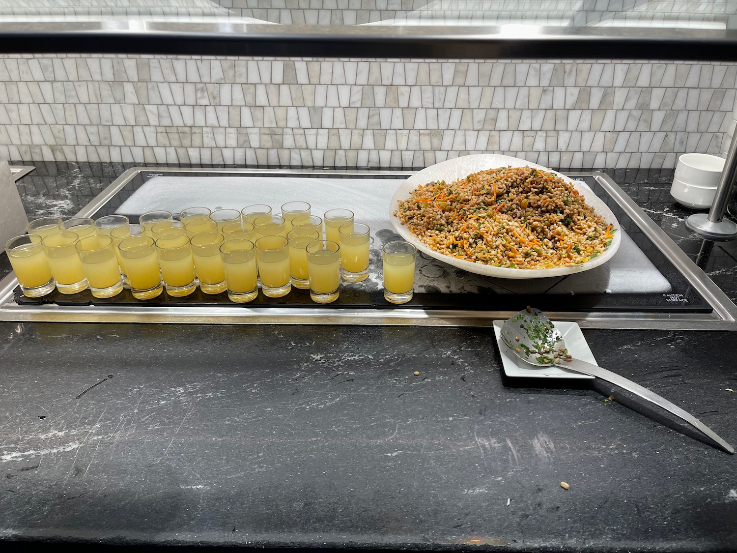 a tray of shot glasses and a plate of food