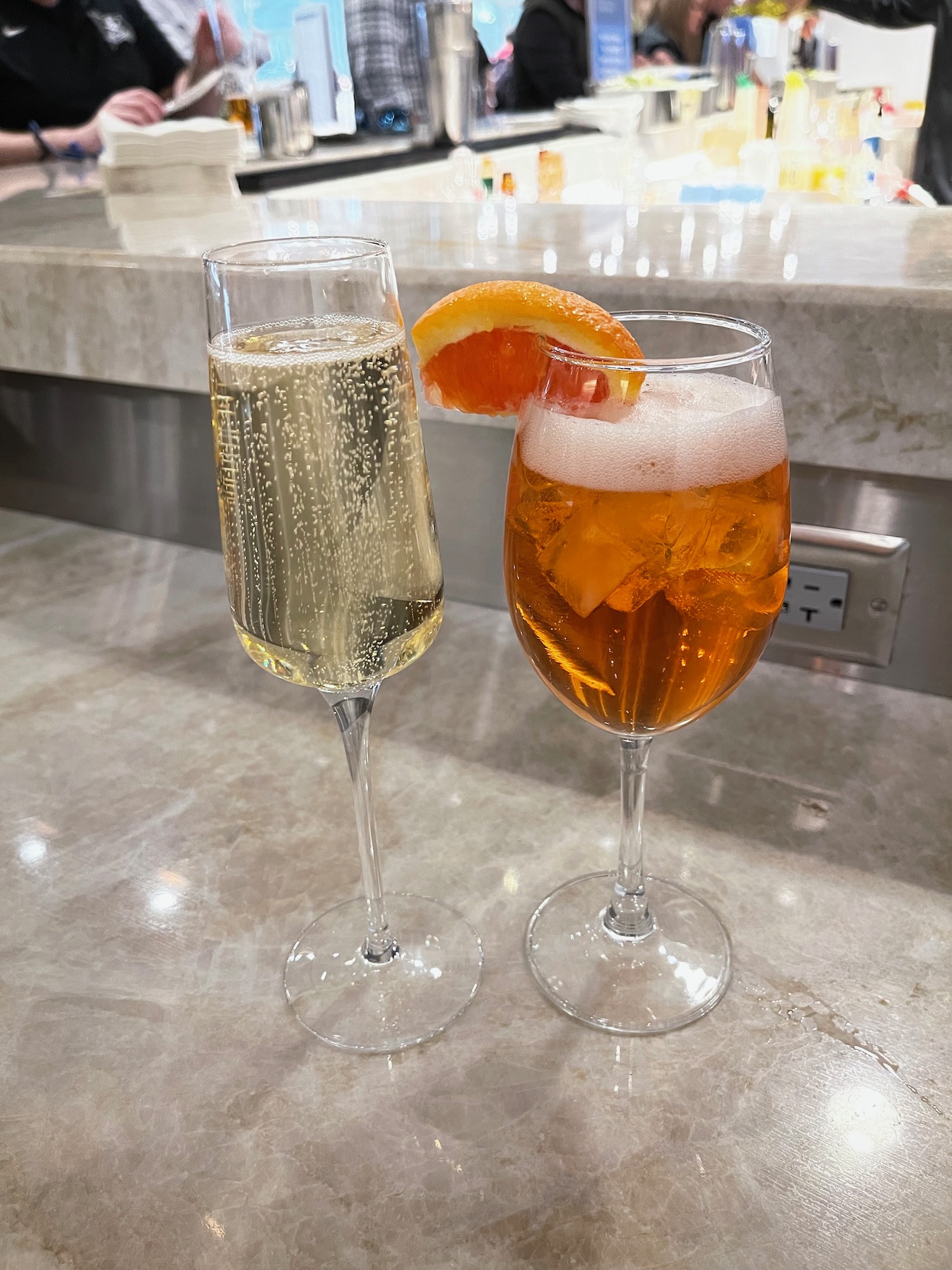 two glasses of champagne and a slice of orange