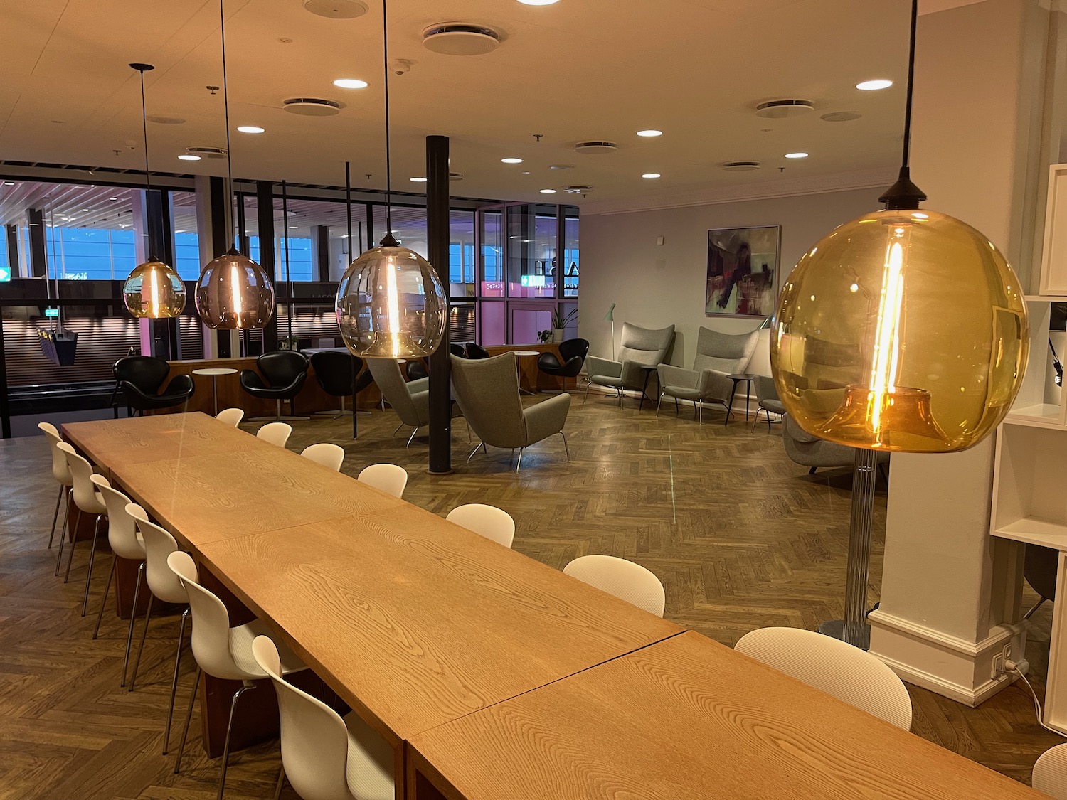 a long table with chairs and lamps