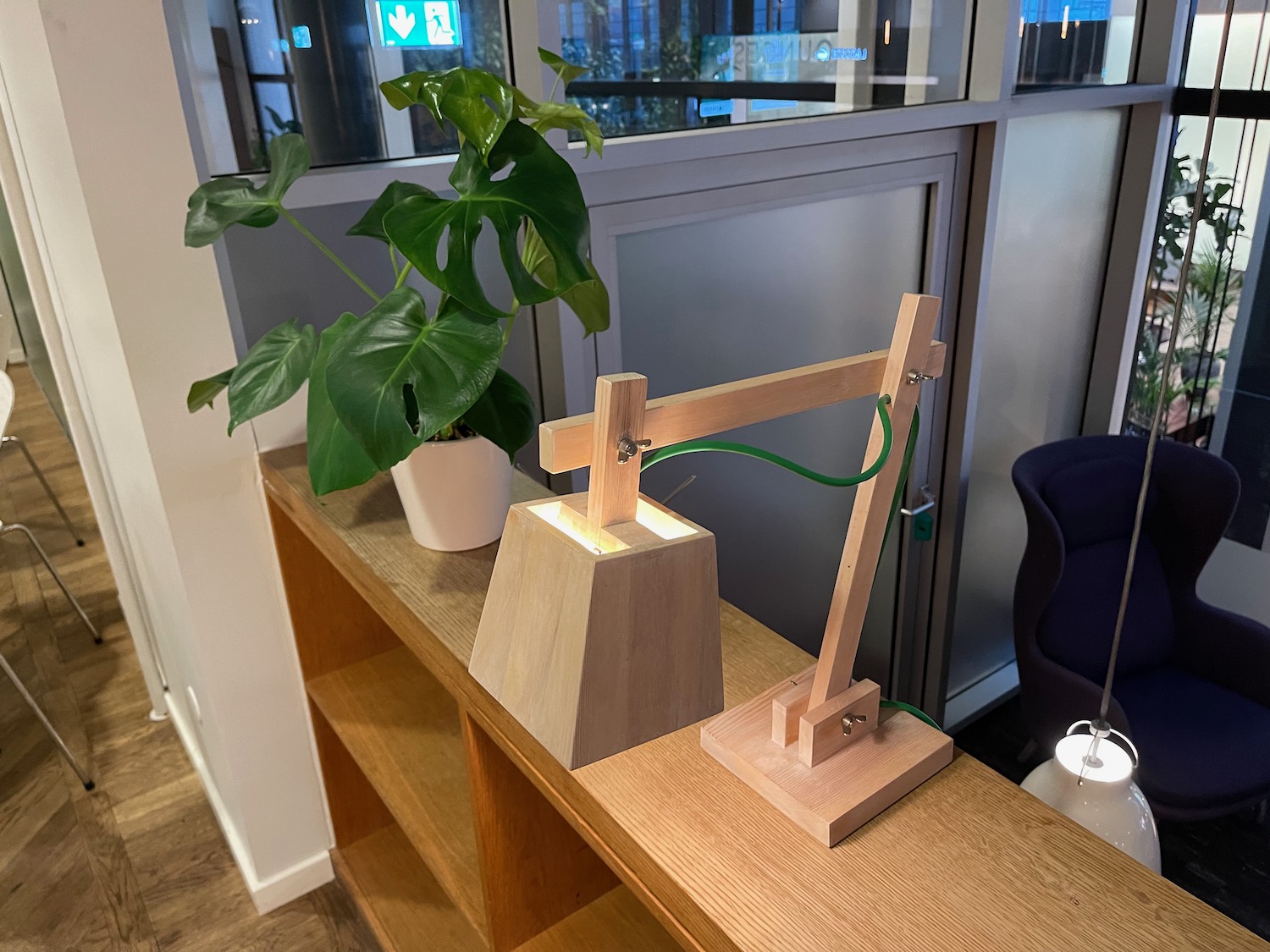 a wooden lamp and a plant on a shelf